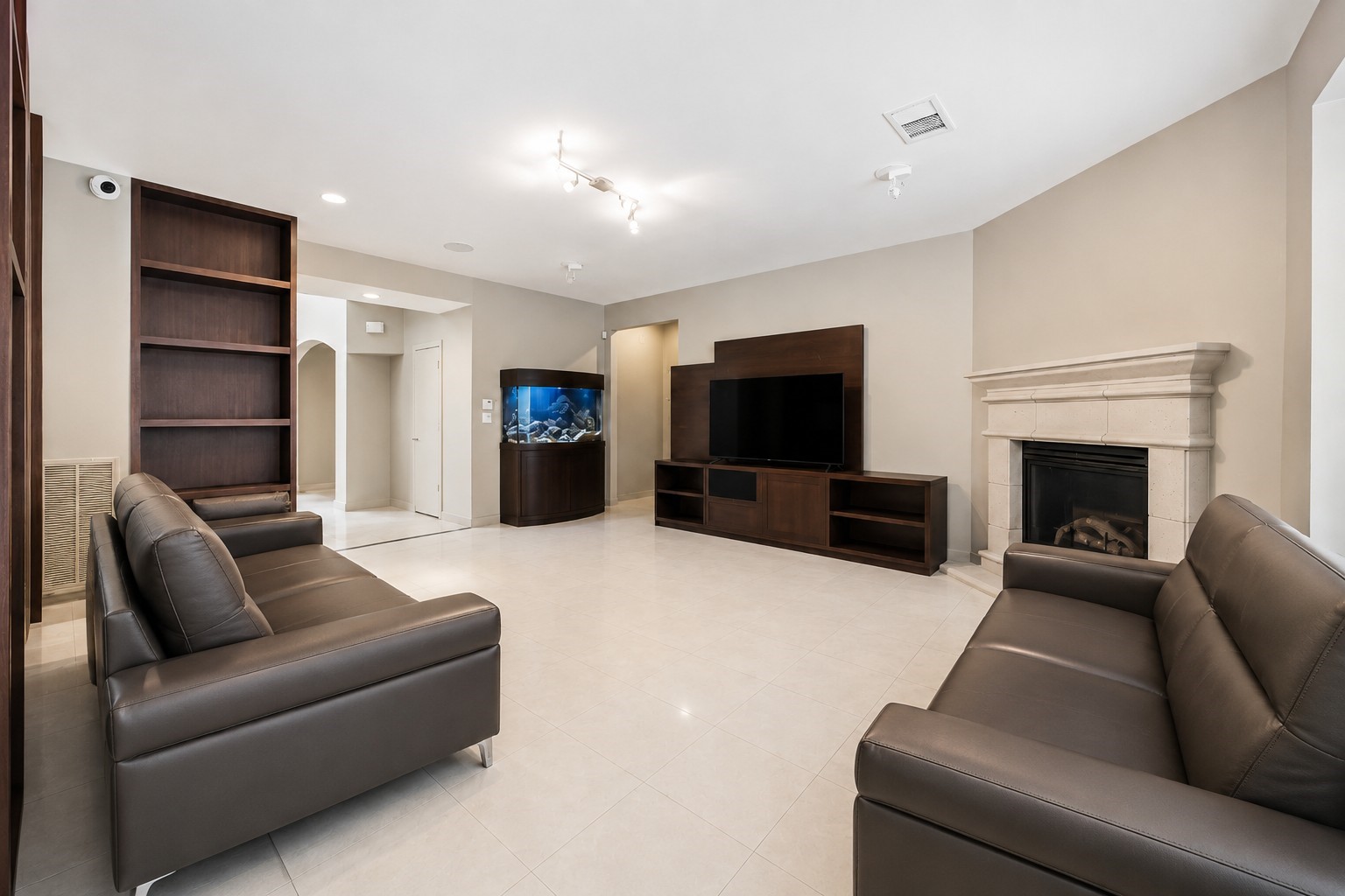 An alternate angle of the family room highlights a sleek, custom-built entertainment unit matching the room's dark-stained wooden bookshelves.