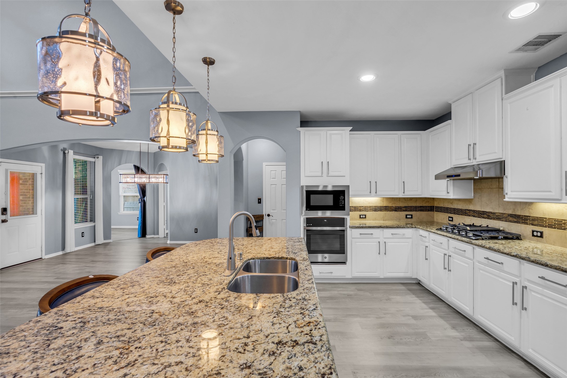 Spacious kitchen with elegant granite countertops, stainless steel appliances, and stylish pendant lighting, offering a perfect blend of functionality and modern design.