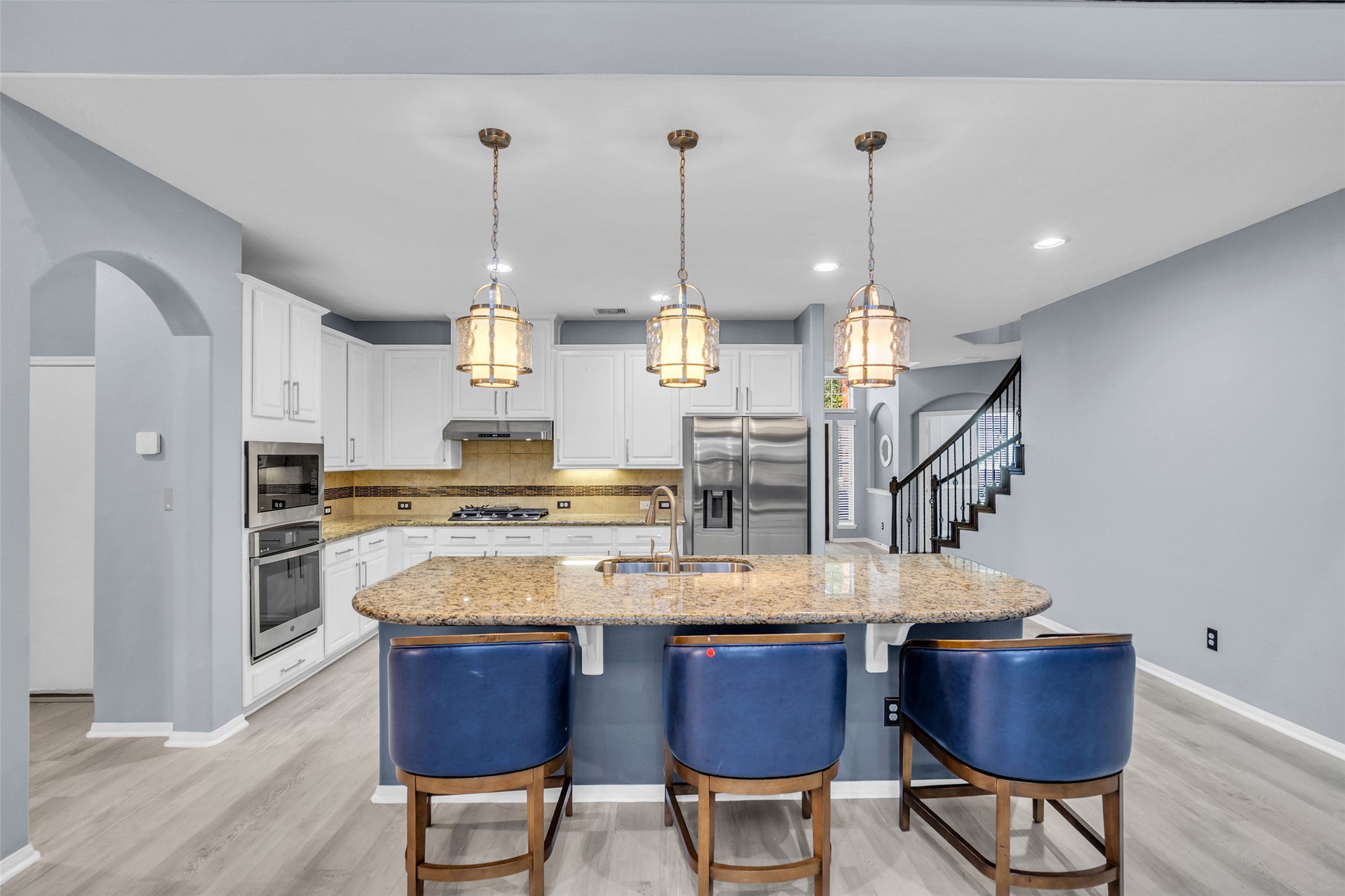 Elegant kitchen with modern stainless steel appliances, granite countertops, and a spacious island with seating.