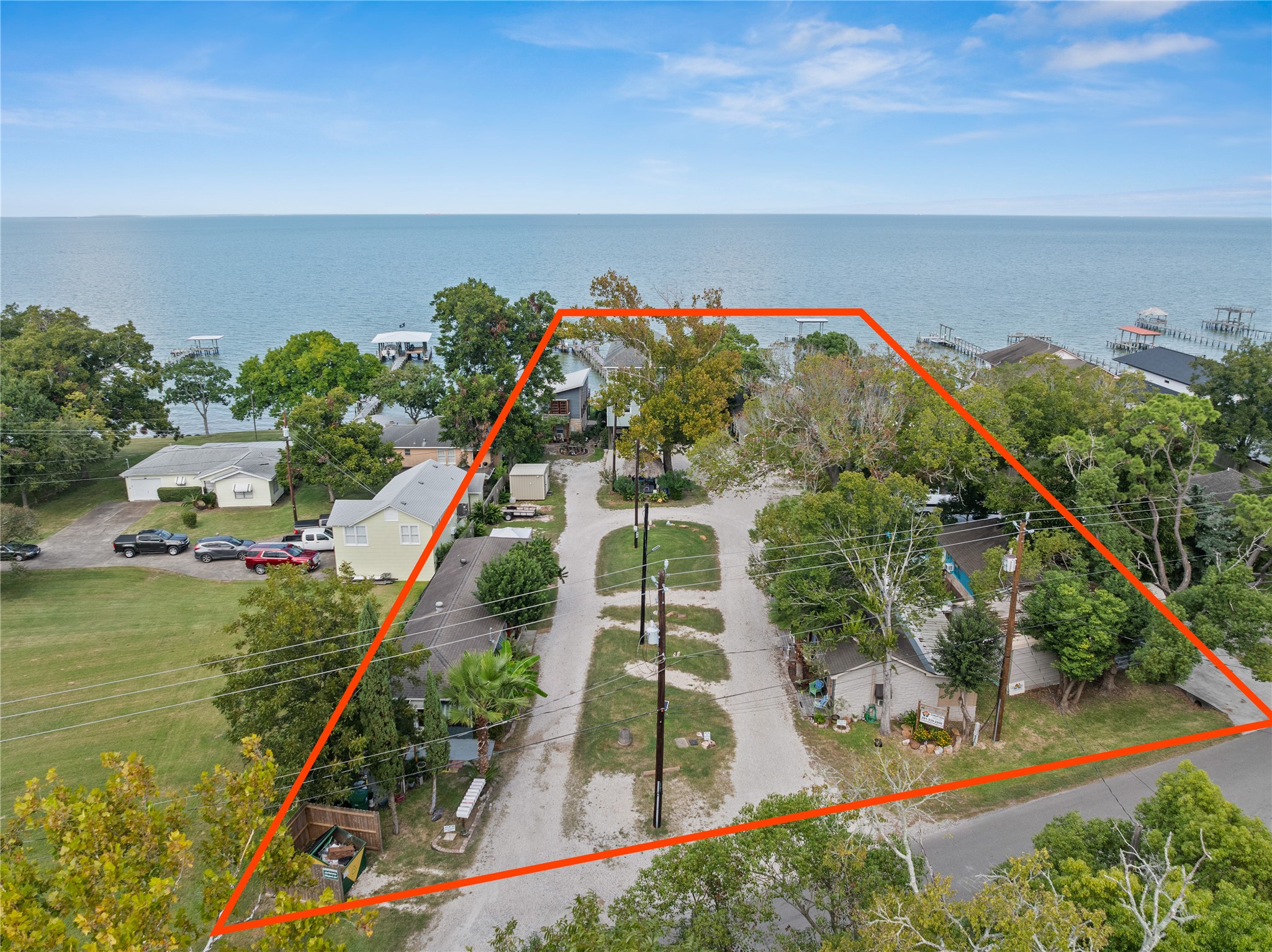 This photo from Bayshore shows the spacious, tree-lined property outlined in red, positioned near the waterfront.