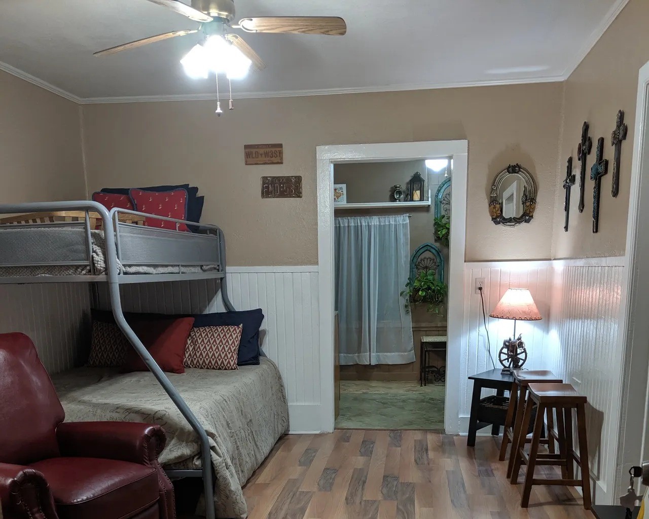 Charming and cozy room in the Tejas featuring a stylish bunk bed, warm wood flooring, and tasteful decor. Ideal for comfortable living with inviting lighting and a welcoming ambiance. Perfect for creating lasting memories.