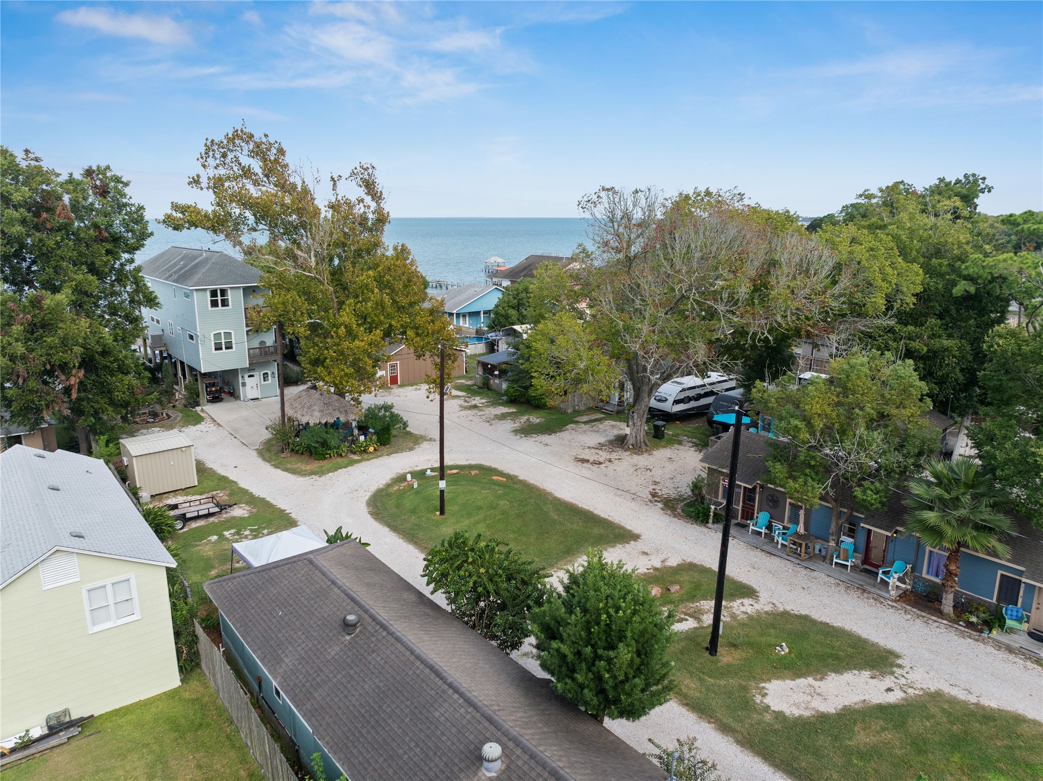 This photo shows the charming coastal property with a view of the bay. The homes and cottages are surrounded by trees, and a road leading to the waterfront, creating a peaceful, bay side atmosphere.