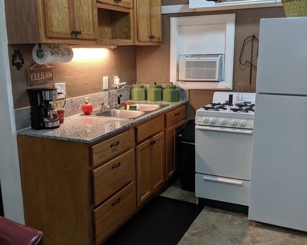 Cozy kitchen in the Tejas with charming wooden cabinets, sleek granite countertops, and modern appliances, perfect for culinary enthusiasts.