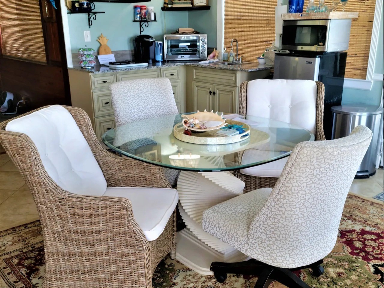 Cozy and inviting, this Bay Room features elegant wicker seating and a stylish glass-topped table, perfect for intimate gatherings or relaxing moments.