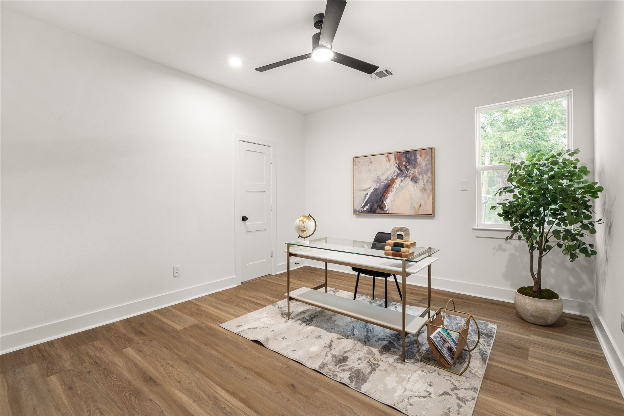 A secondary bedroom, staged here as a home office, is filled with natural light and offers the flexibility to
serve as a guest room, workspace, or creative studio.
