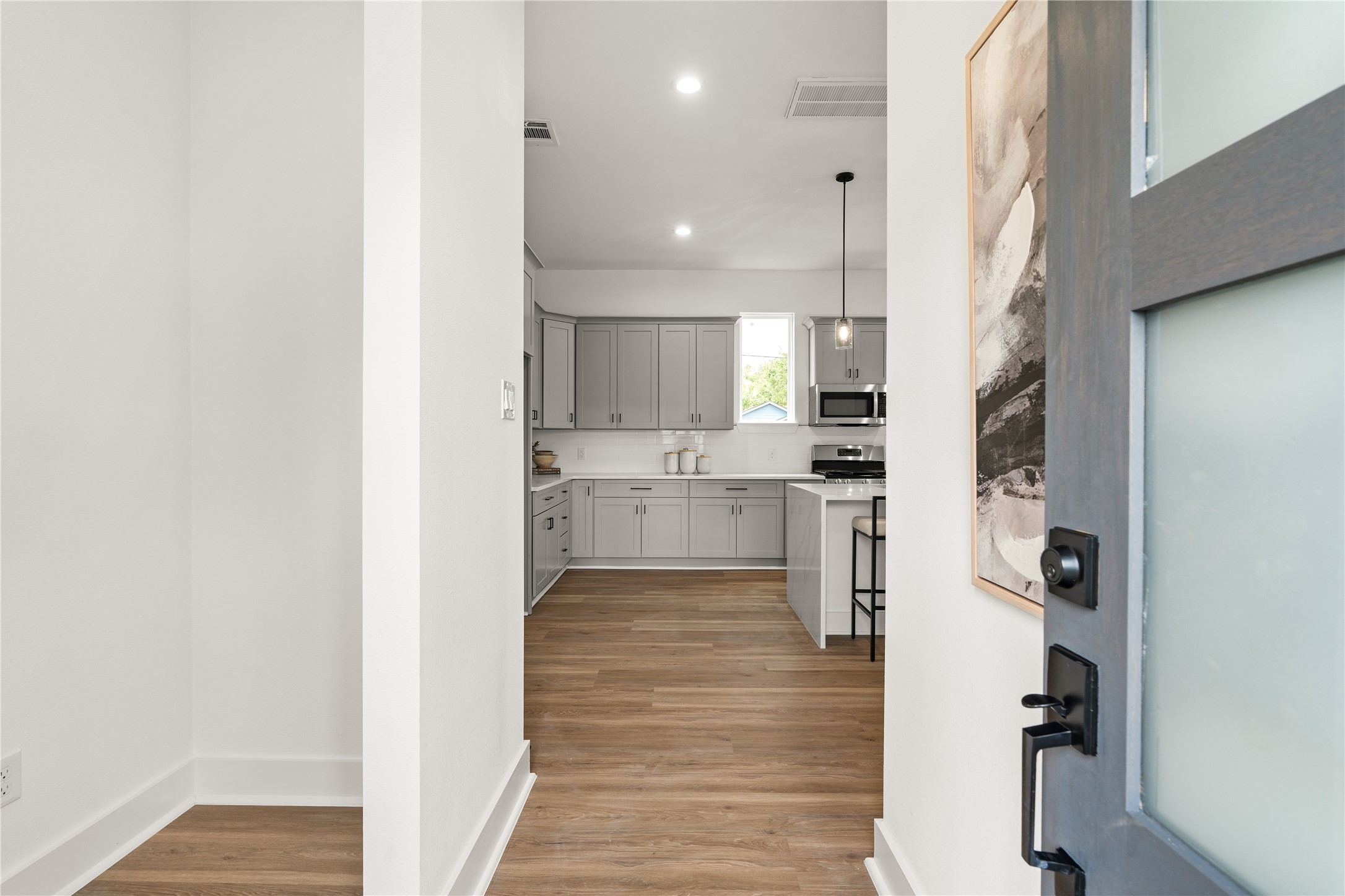 From the front door, a clear sightline draws the eye straight to the kitchen, where soft gray cabinetry and
bright white finishes offer an inviting, well-ordered introduction to the home.
