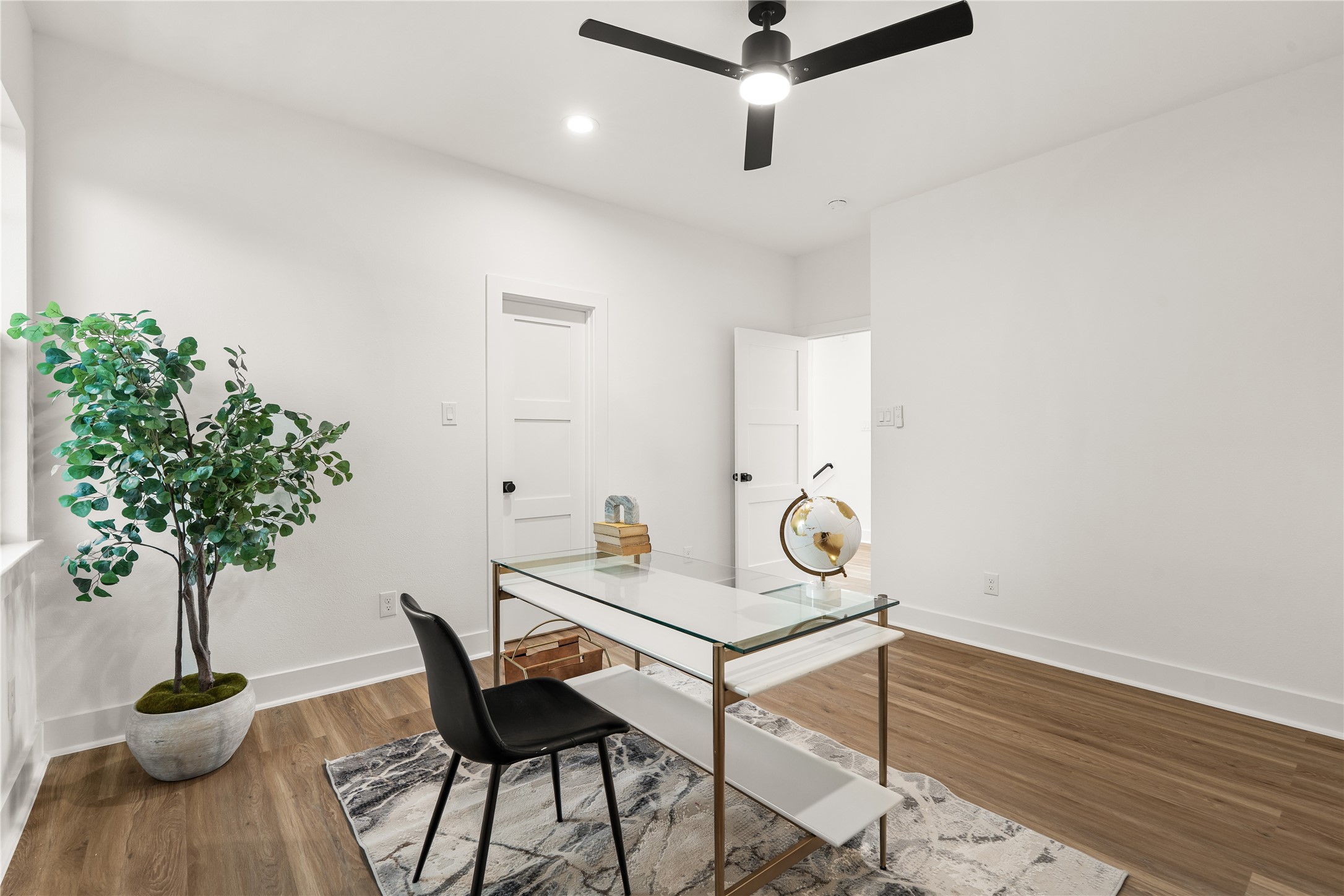 Clean white walls, a matte-black ceiling fan, and its own closet make this versatile room an easy fit for
remote work or overnight guests alike.