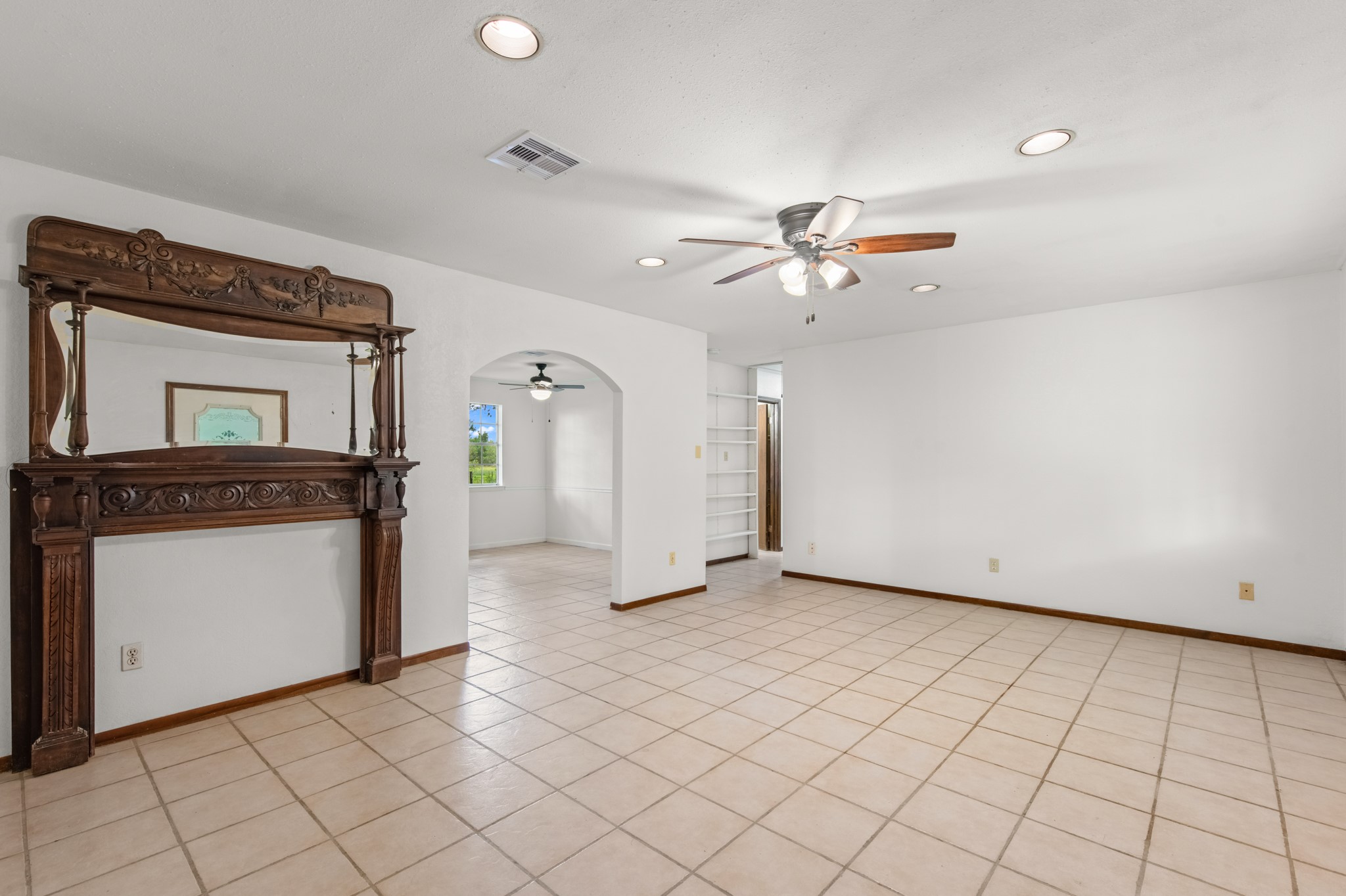 Spacious living room featuring tile flooring and recessed lighting.