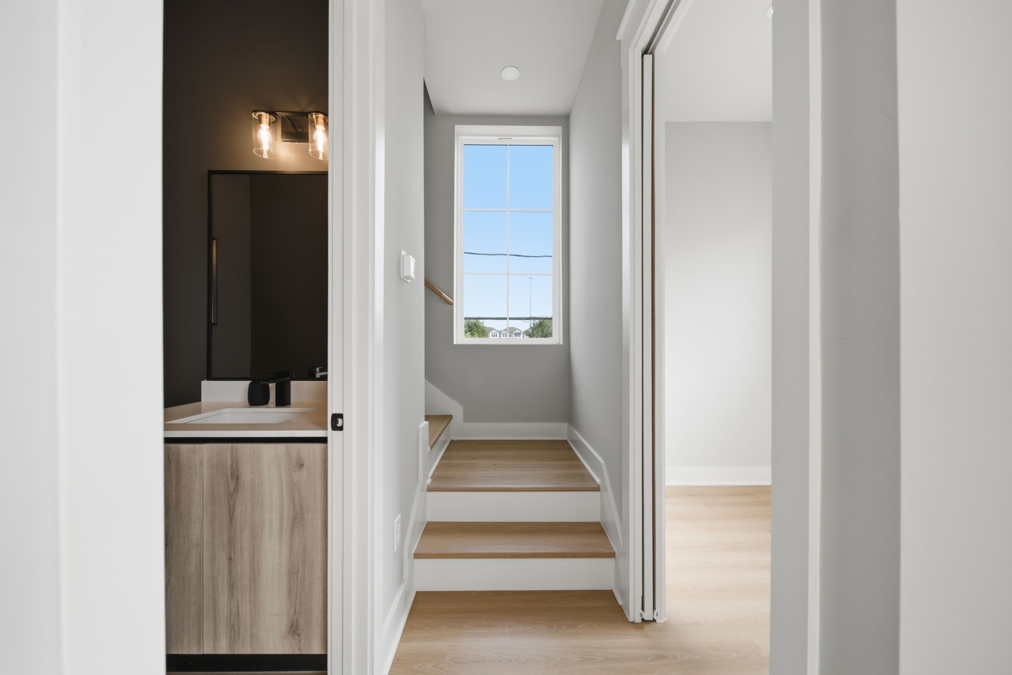 Stairway view of convenient access to the dedicated study and powder room located on the second floor.