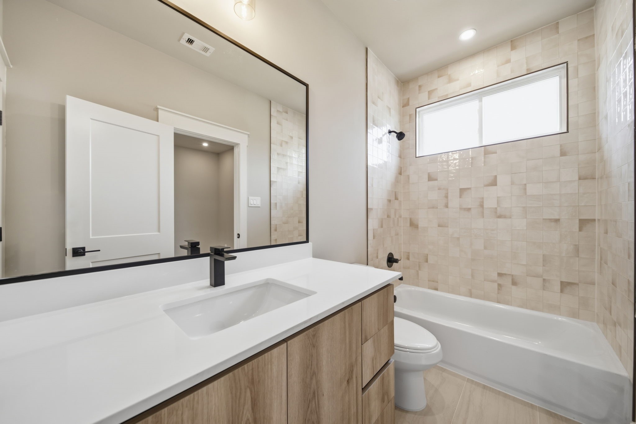 Full bathroom en-suite for the secondary bedroom with a tub/shower combo and a warm and inviting feel.