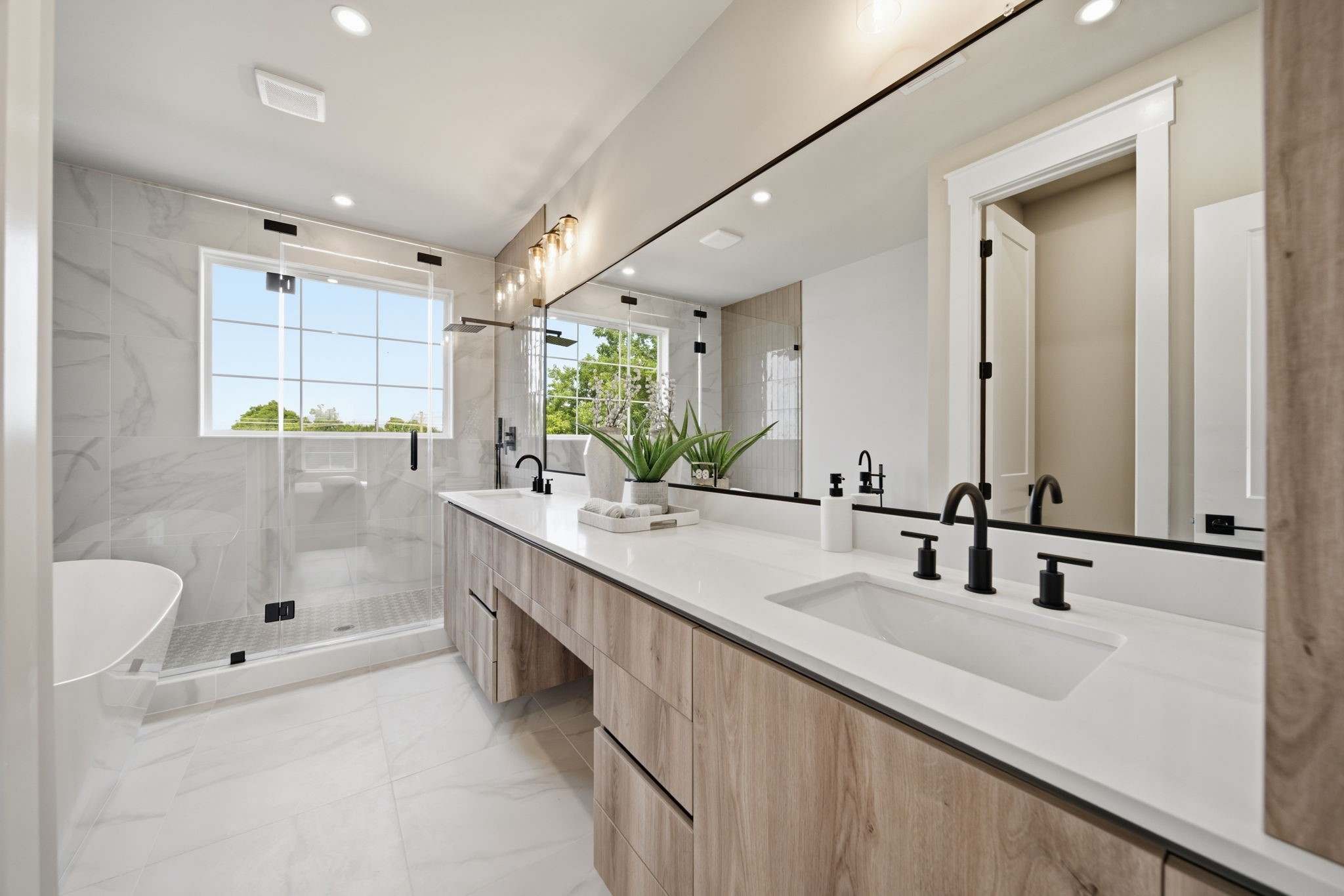 Primary bath features a oversized walk-in shower, dual sinks, vanity, and a soaking tub for a spa like feel at home.