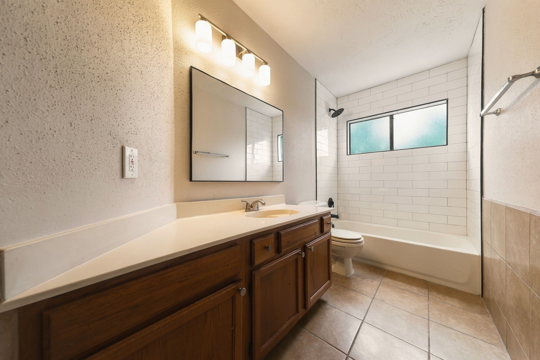 Large hall bath between Bedrooms #2 and #3 with new shower tile, light fixture and mirror.