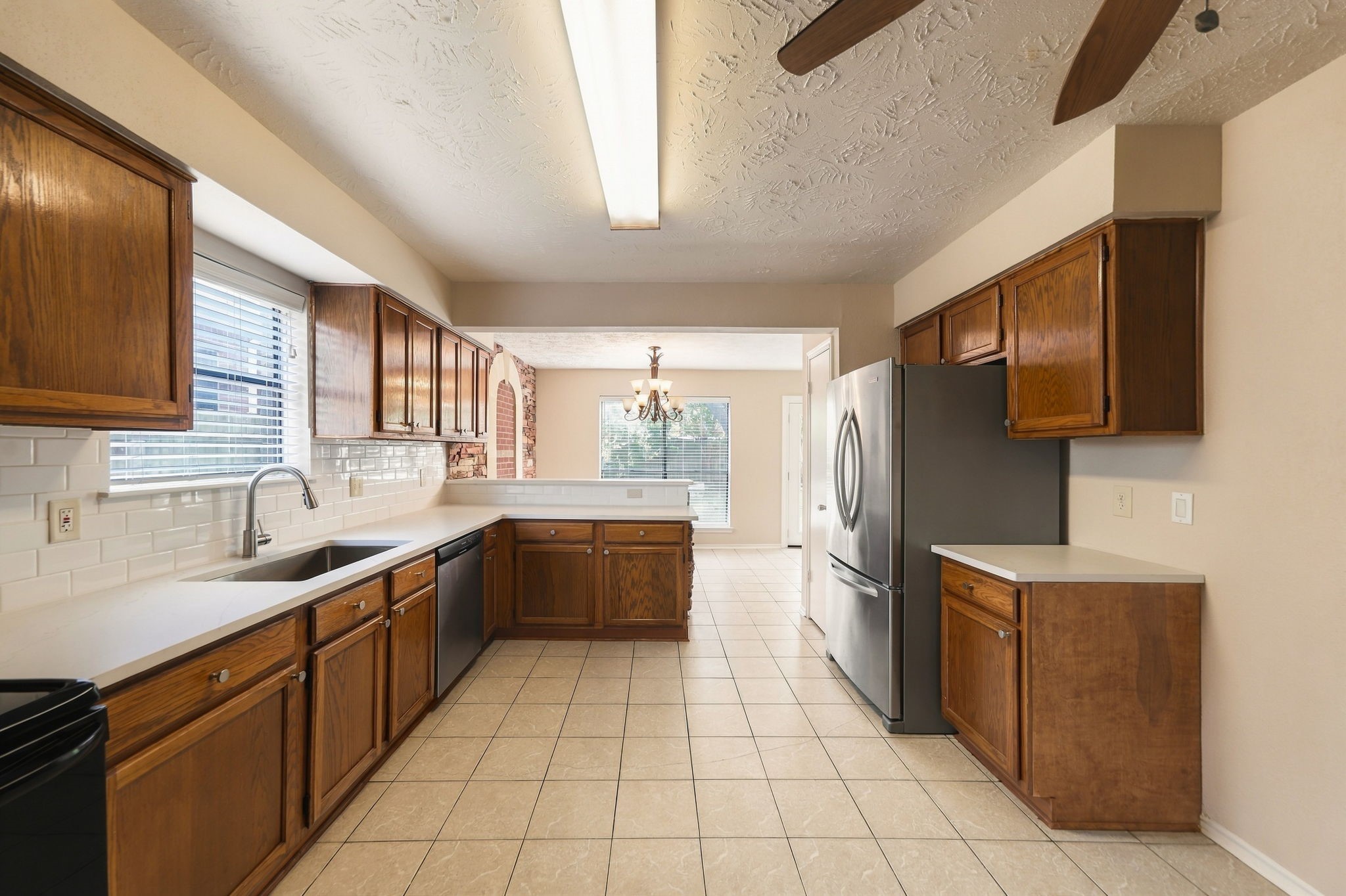 New quartz counters, subway backsplash, hood vent, sink, faucet, and cabinet hardware.