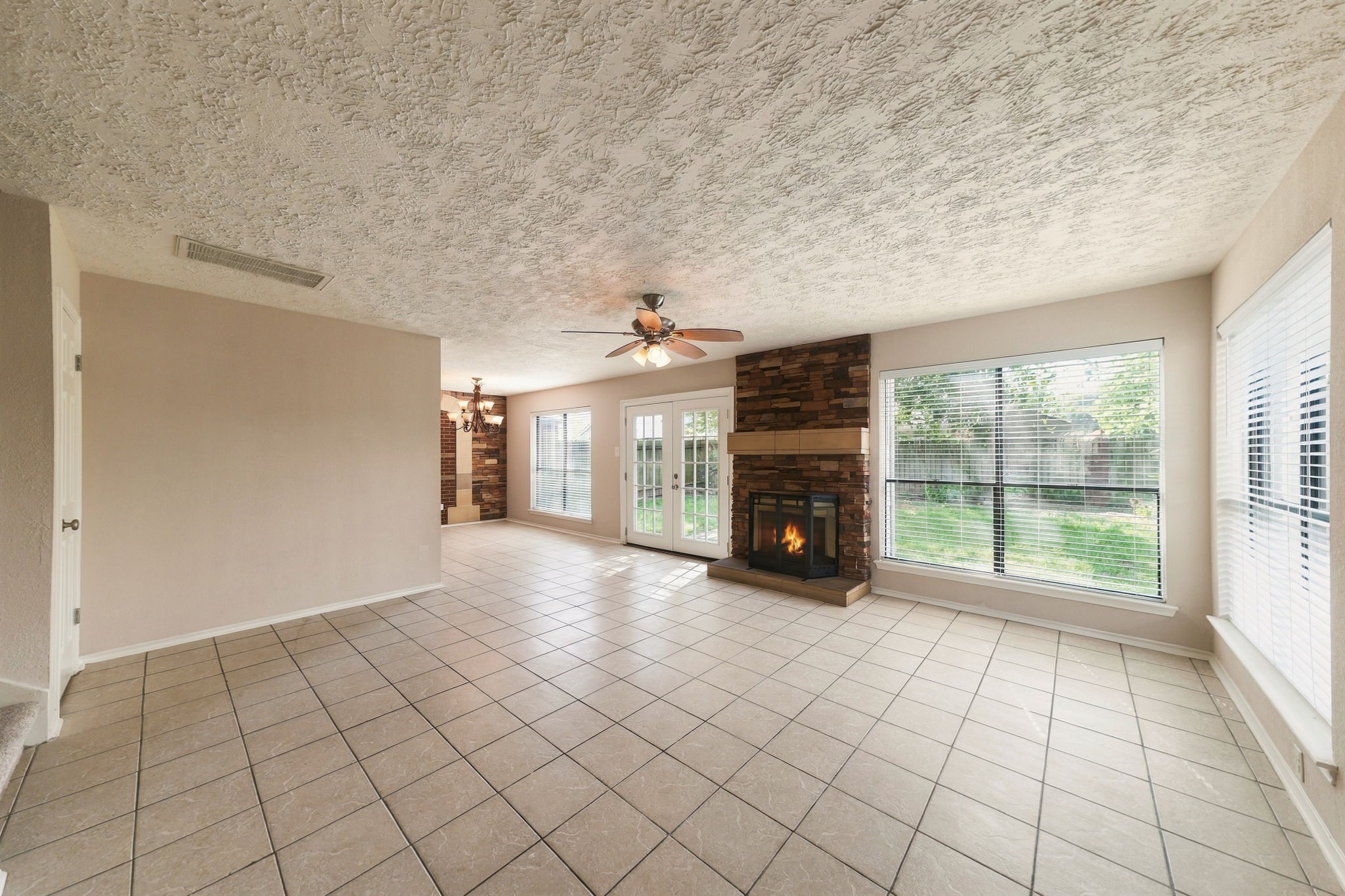 Enter the home into the living room with many windows and natural light.