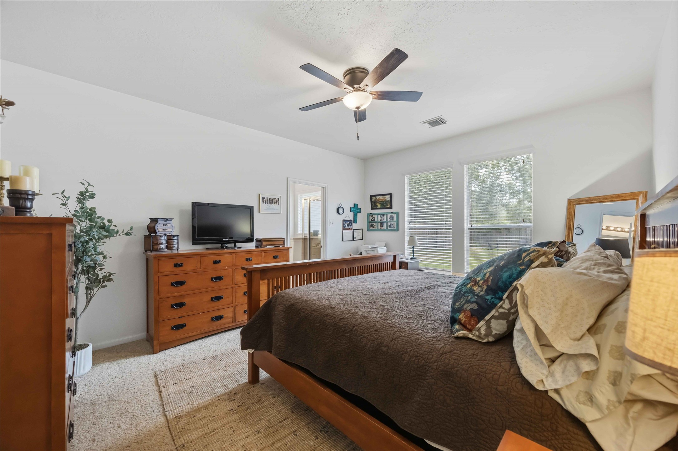 Spacious primary bedroom with two large windows overlooking the backyard and an adjoining private bathroom.