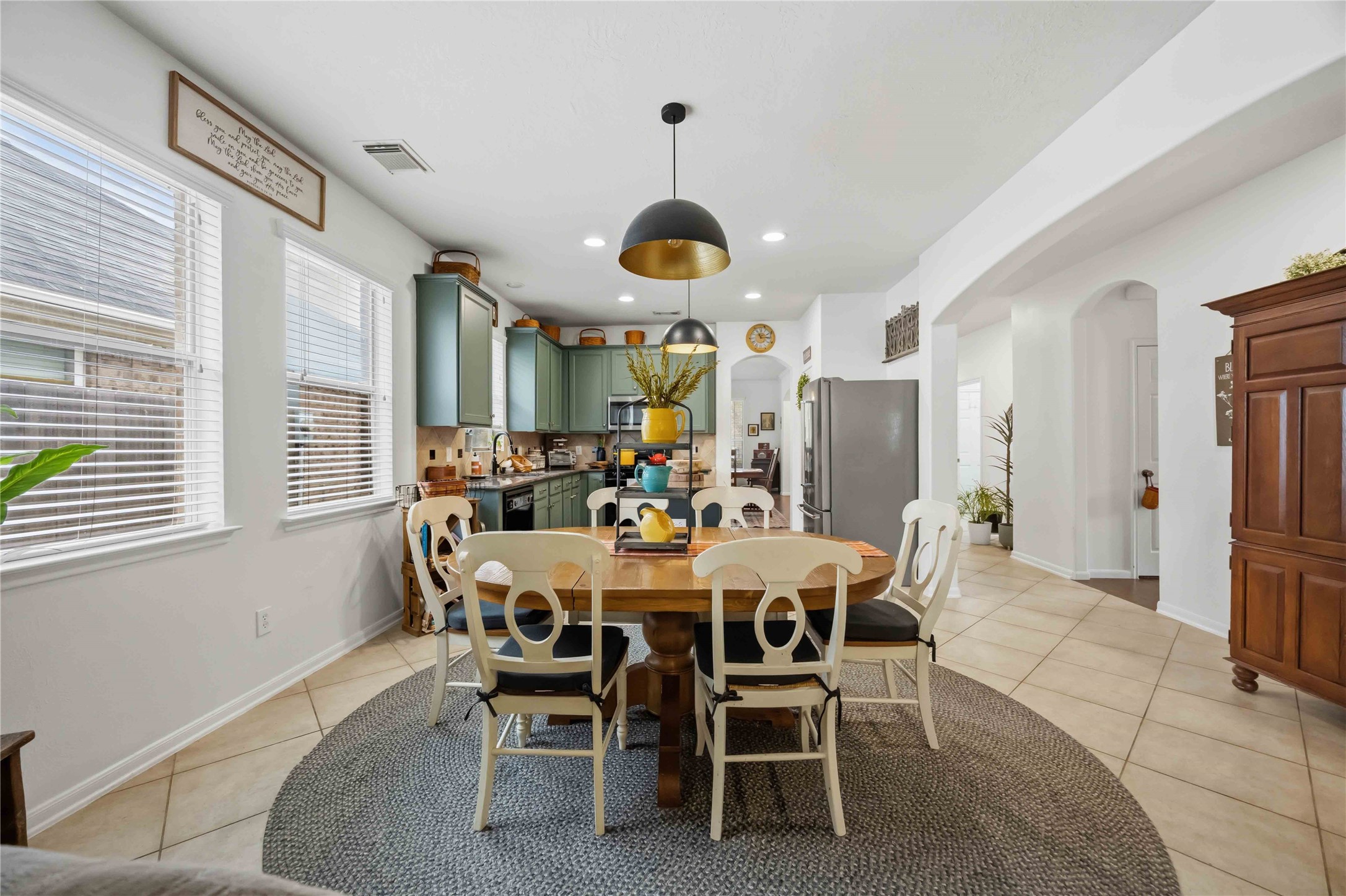 Bright breakfast area featuring tile flooring, large windows, and convenient access to the kitchen.