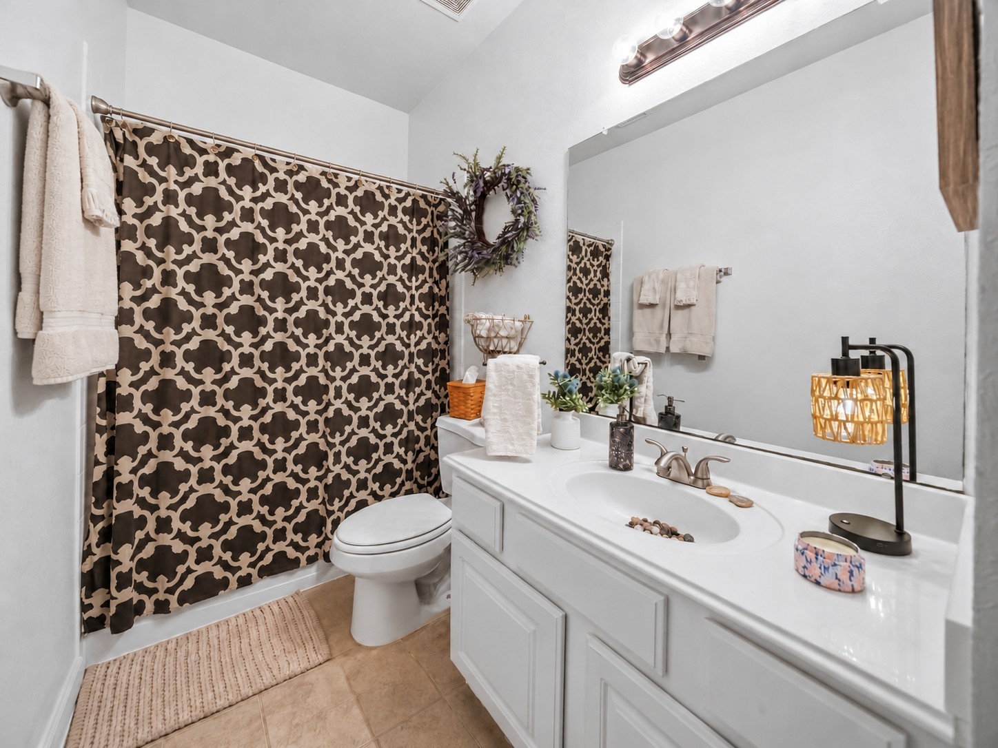 Full secondary bathroom featuring a tub-and-shower combination, single-sink vanity, and large wall mirror.