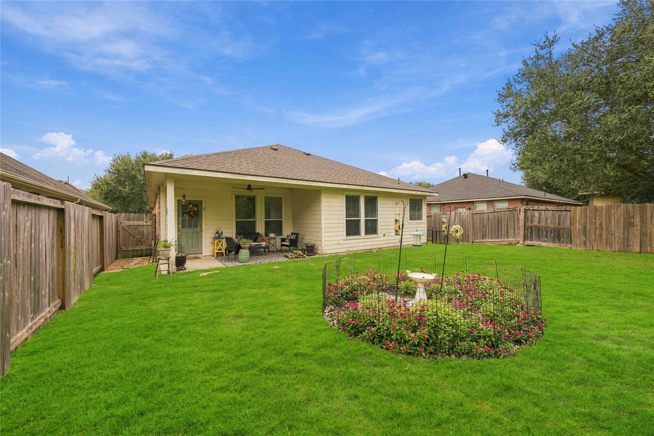 Rear exterior showcases the covered patio, multiple windows, and ample outdoor space for recreation.
