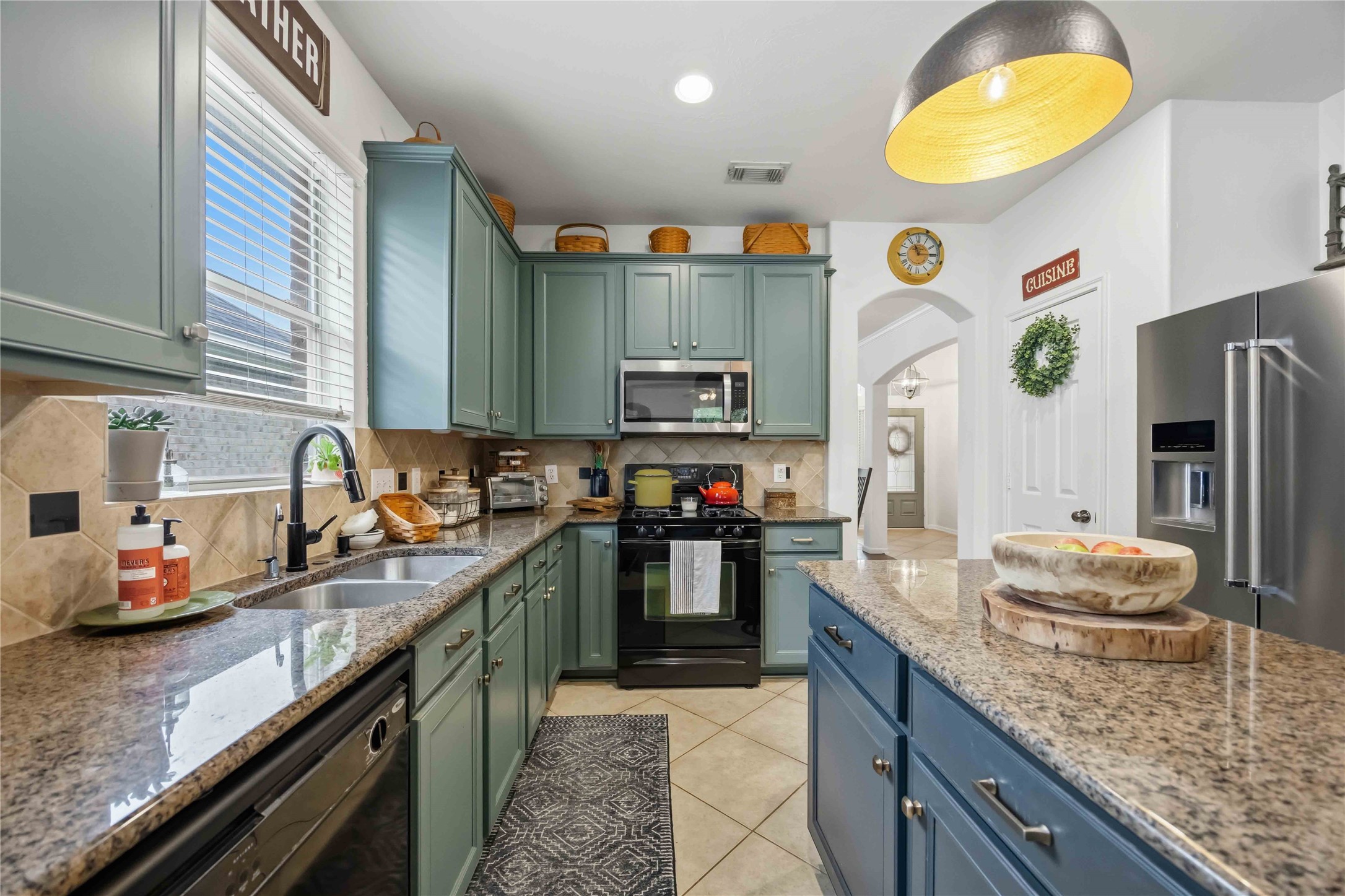 Kitchen features granite countertops, a center island, ample cabinetry, and a stylish tile backsplash.
