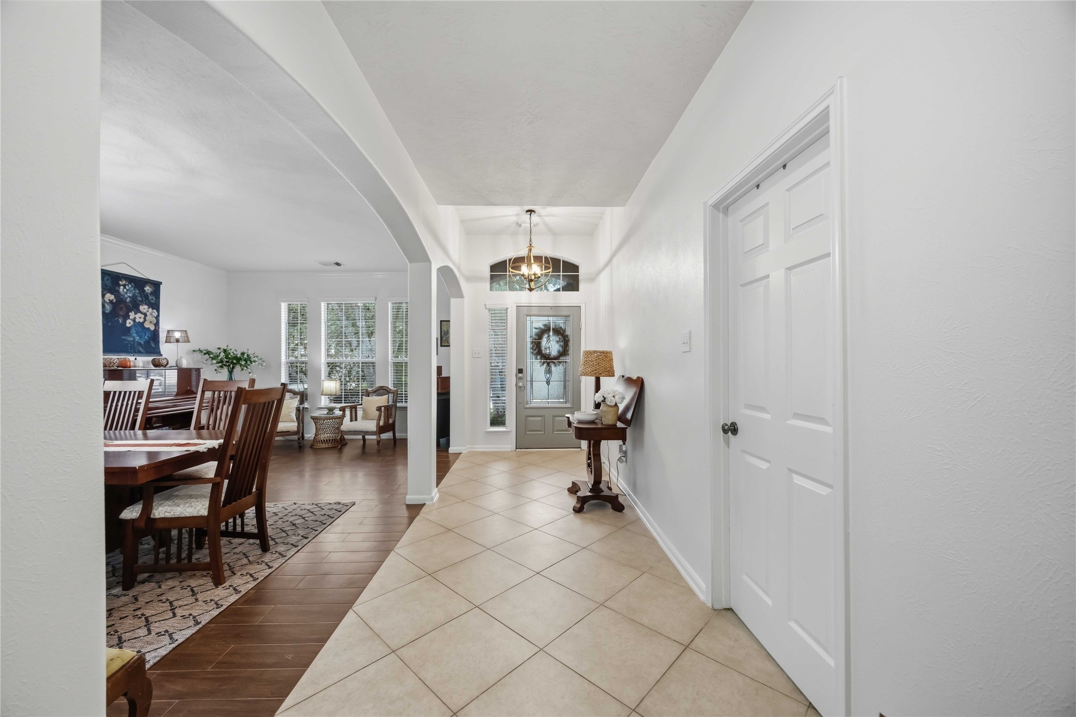 Welcoming foyer with high ceilings, tile flooring, and an elegant entry chandelier.