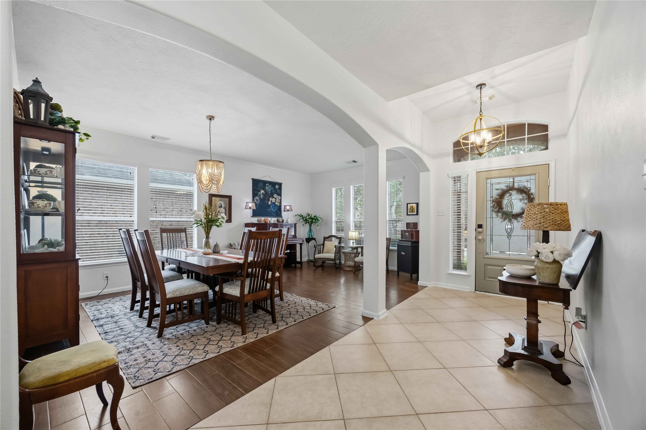Open view of the foyer and dining area showcasing architectural arches, high ceilings, and a seamless layout for entertaining.