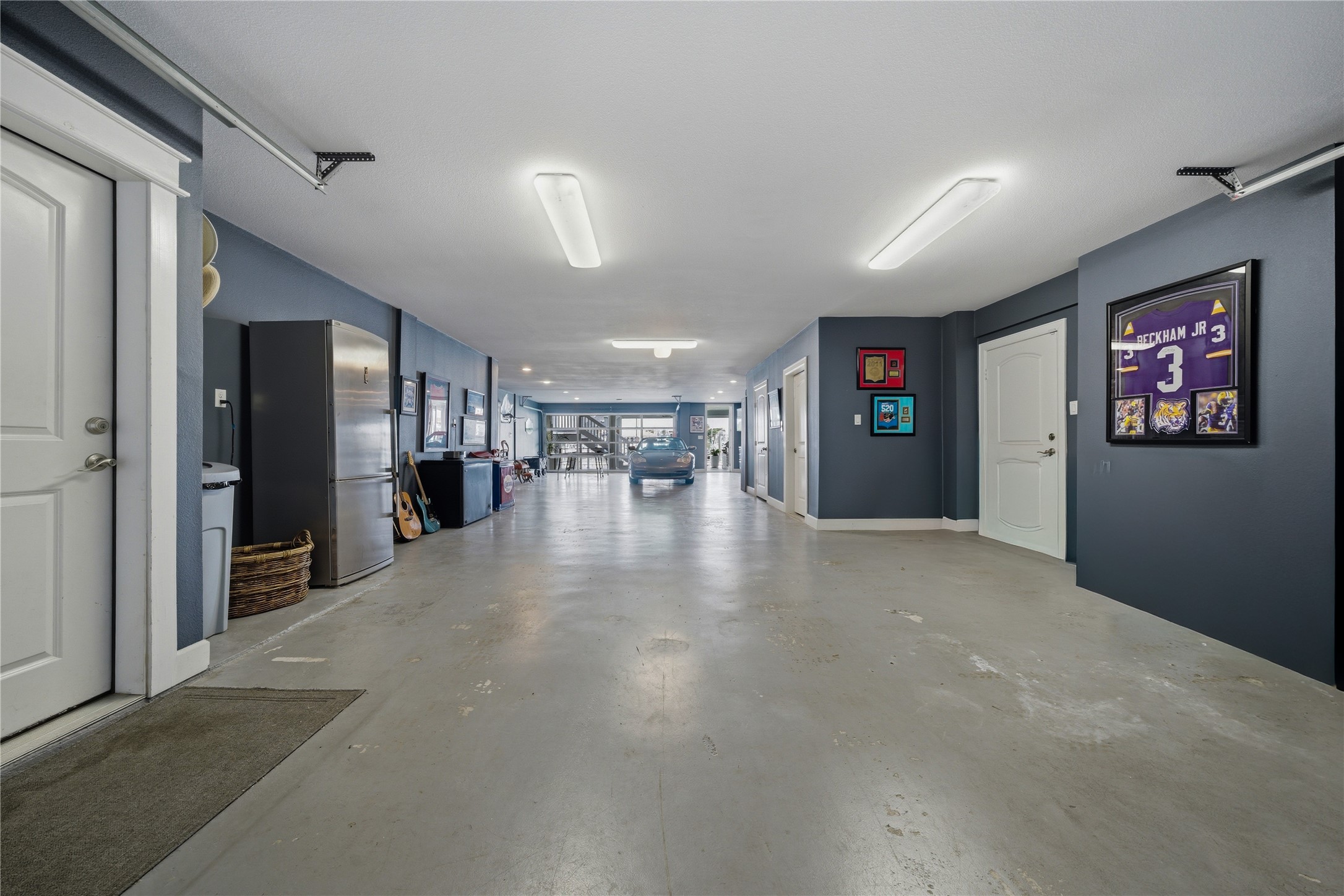 The garage extends the entire depth of the house, with a glass garage door leading to the back patio.