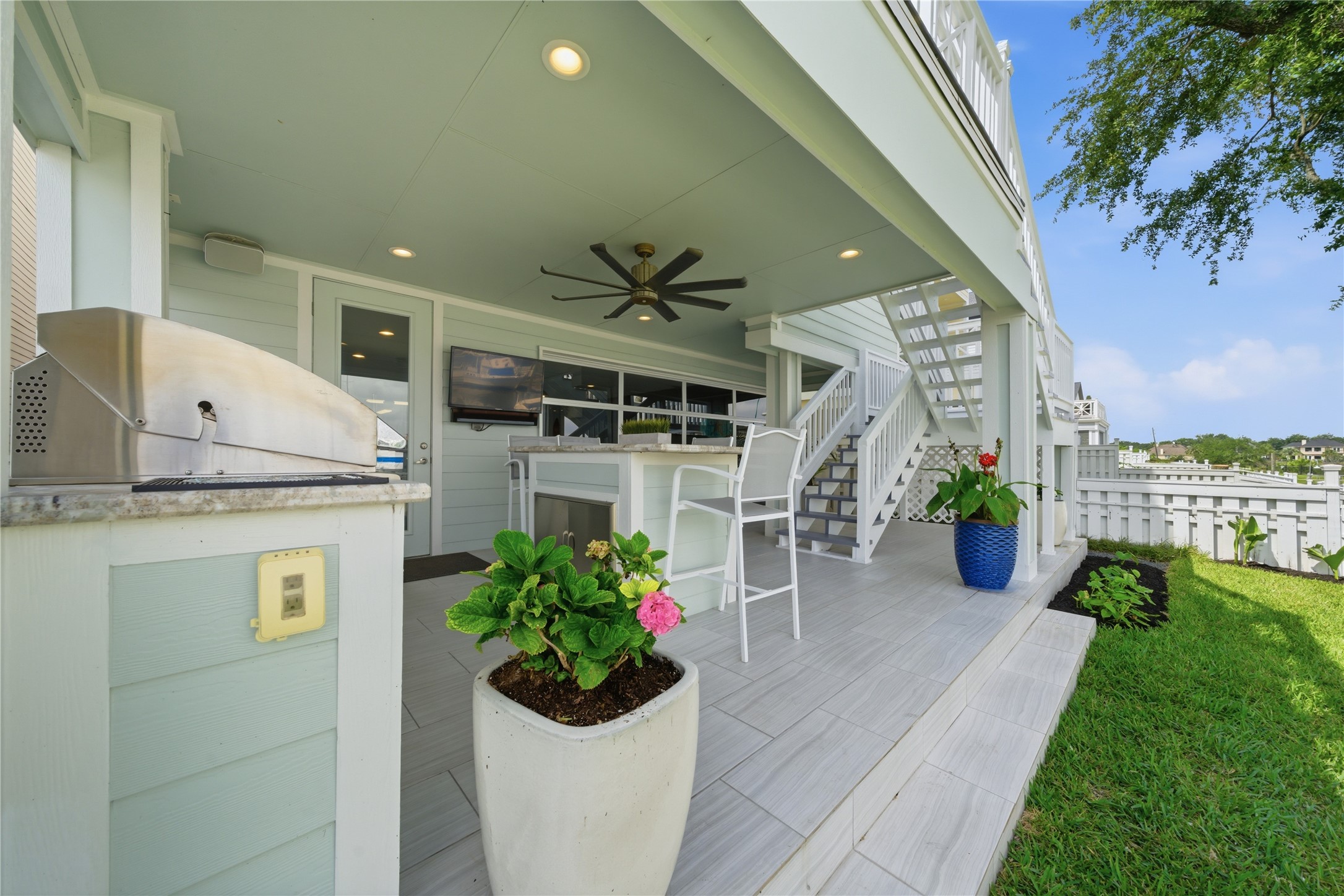 The patio off of the garage with the outdoor kitchen and stairs that go up to the 2nd floor balcony, with easy access to the kitchen.