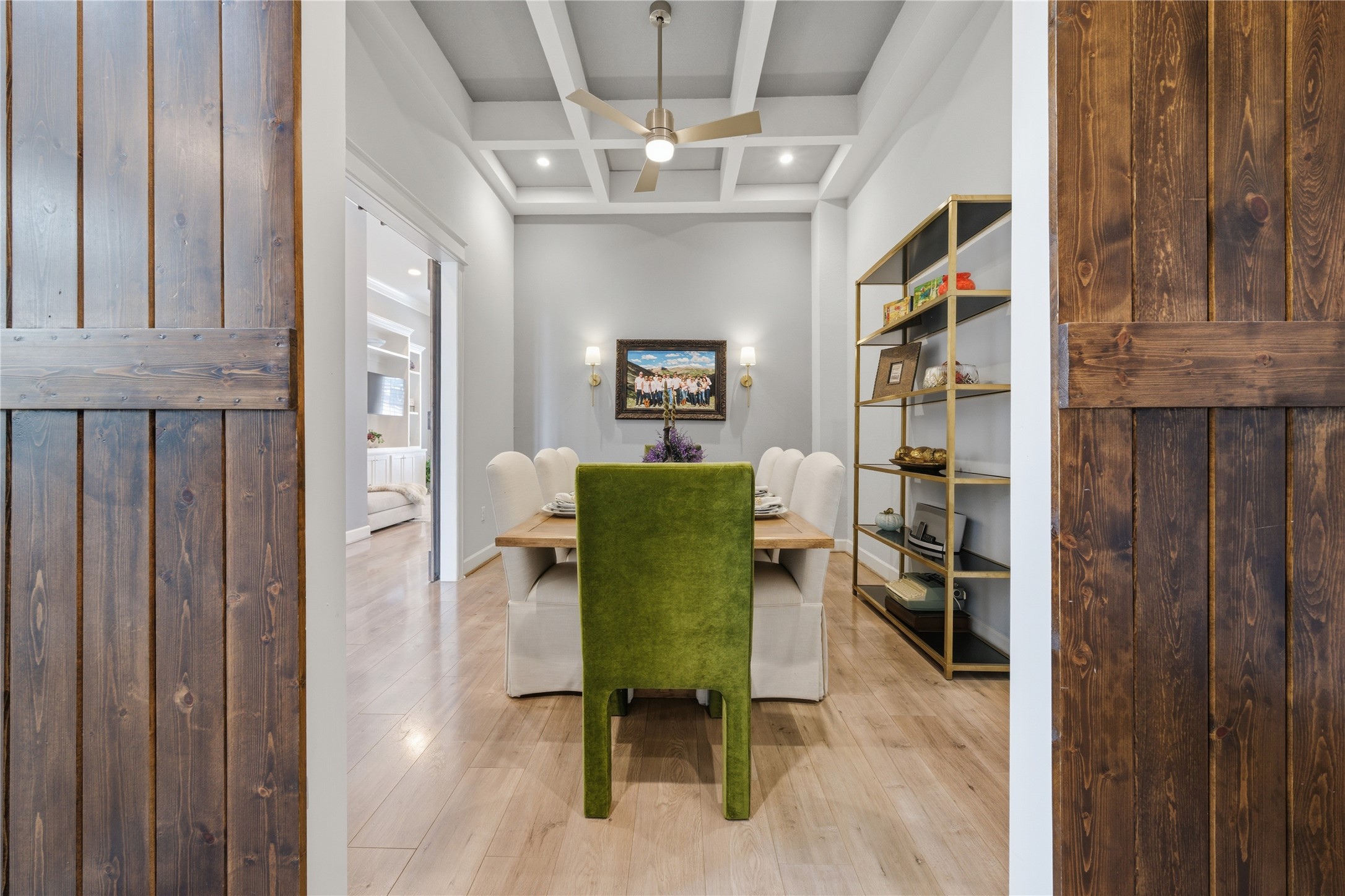 The dining room has dual entry, both with wood barn doors.  Notice the coffered ceiling.