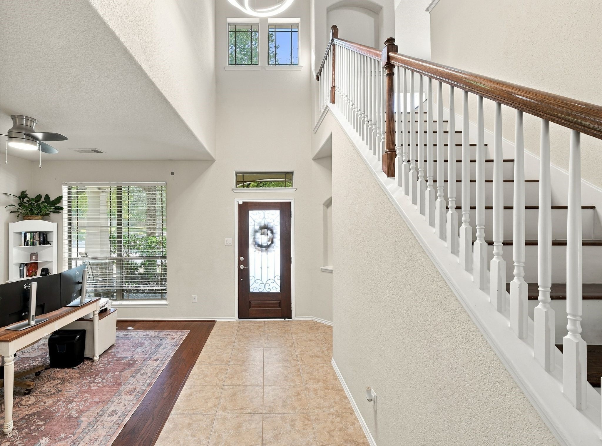 Elegant entryway with a high ceiling and abundant natural light, featuring a stylish staircase with wooden accents. Elegant entryway with a high ceiling and abundant natural light, featuring a stylish staircase with wooden accents.