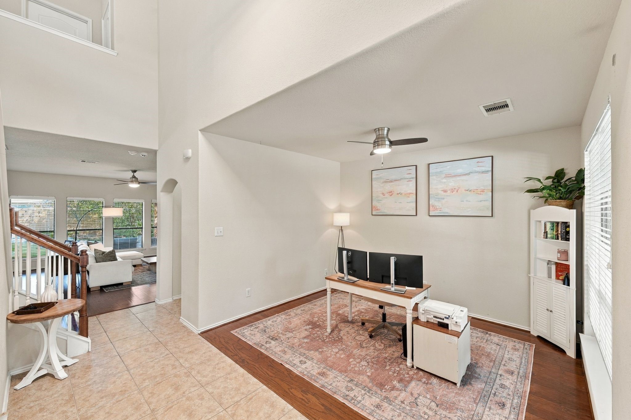 Spacious open-plan flex area with a office nook featuring elegant wood flooring and ample natural light, leading to a cozy living space ideal for relaxation. Spacious open-plan flex area with a office nook featuring elegant wood flooring and ample natural light, leading to a cozy living space ideal for relaxation.