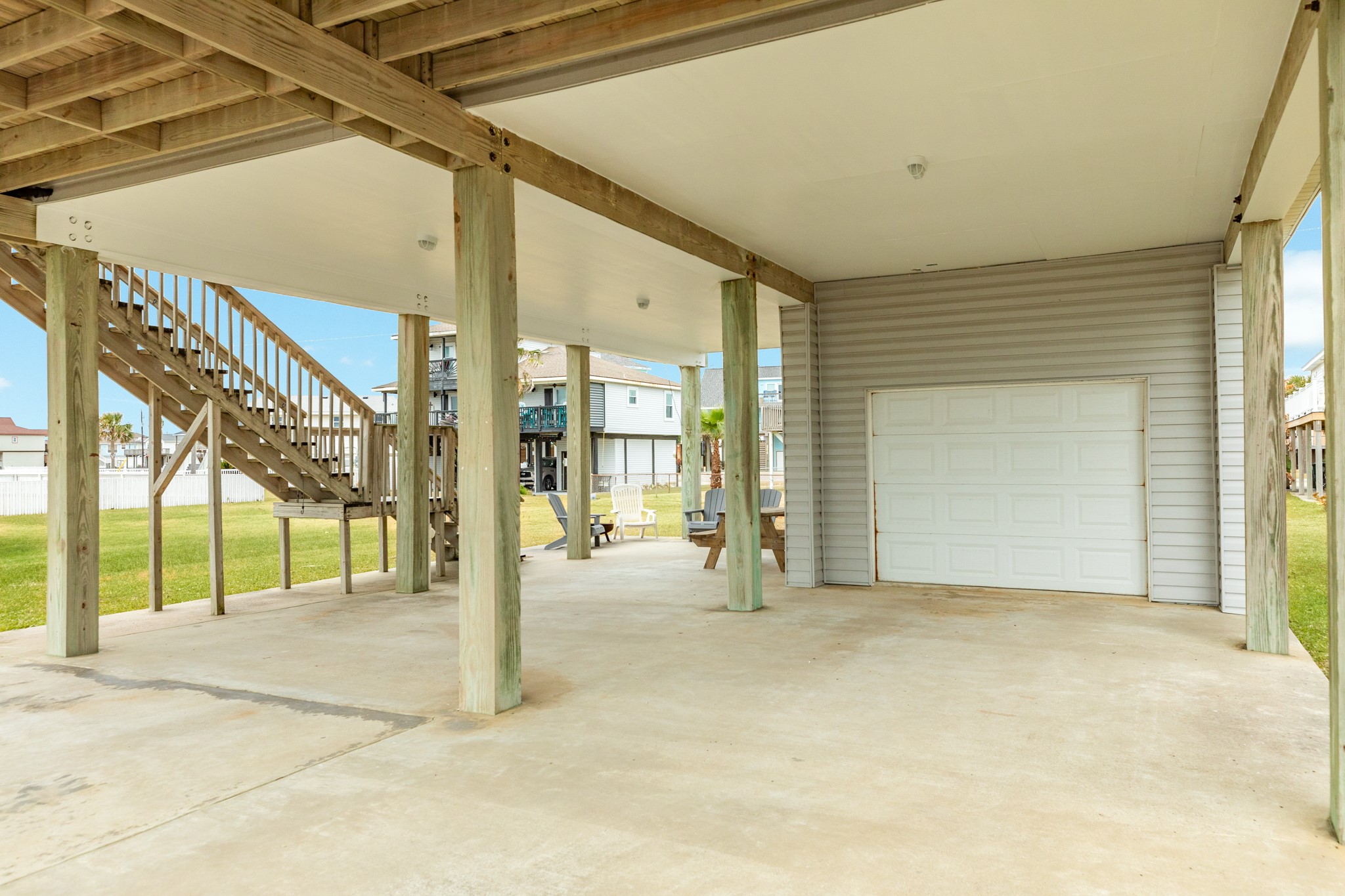 View under home. Single car garage space, double wide & long driveway provides for plenty of parking and a side patio area.