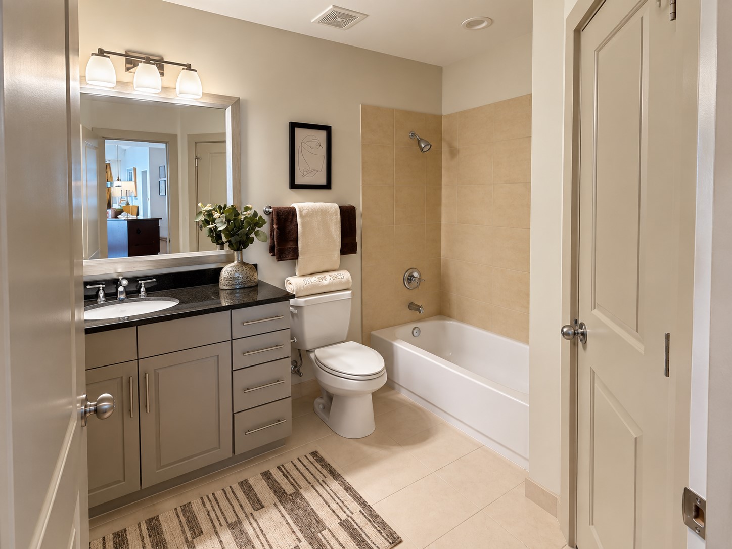 A beautifully appointed secondary bath offers the comfort and finish of a private hotel retreat, with a generous vanity, soaking tub and warm neutral finishes. Thoughtful storage makes the space as practical as it is polished, ideal for guests or everyday living.