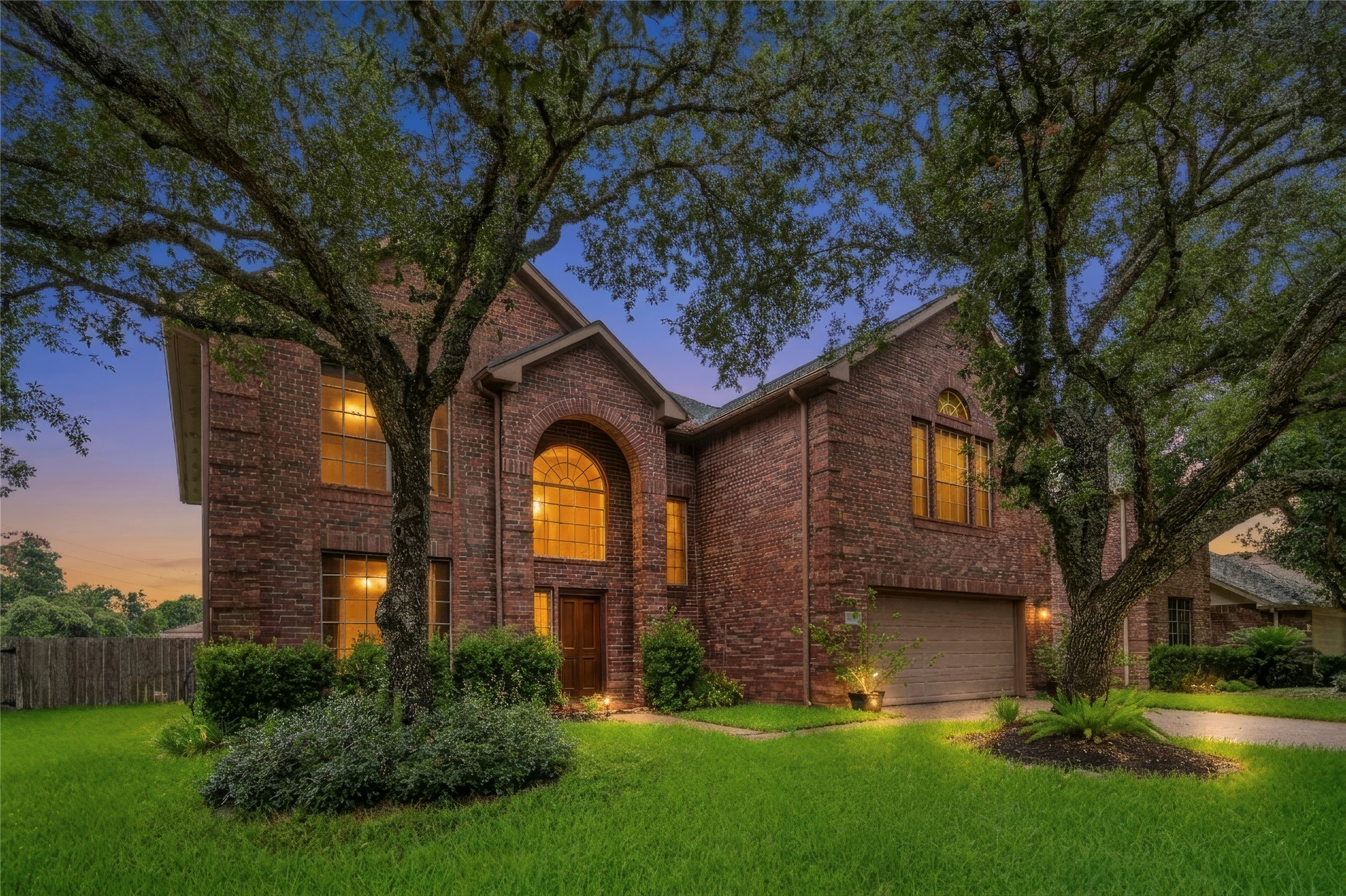 Inviting two-story brick residence framed by mature trees and established landscaping, with striking arched windows that give the home timeless character. The welcoming entry and curb appeal immediately introduce a home designed to feel substantial, established, and comfortable. Inviting two-story brick residence framed by mature trees and established landscaping, with striking arched windows that give the home timeless character. The welcoming entry and curb appeal immediately introduce a home designed to feel substantial, established, and comfortable.