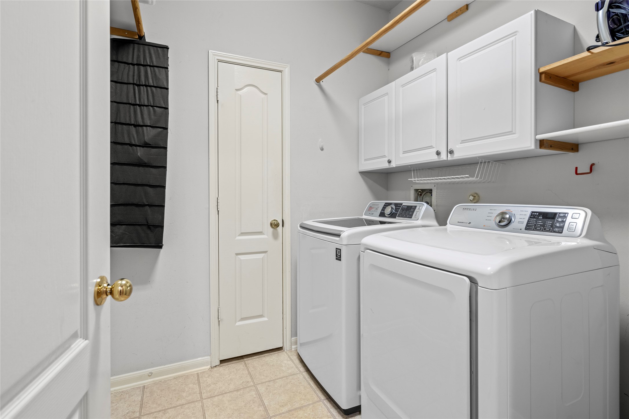 Functional laundry room with built-in cabinetry and shelving that provides valuable organization and storage. For buyers looking beyond cosmetic finishes, this is the kind of everyday utility that helps a home work efficiently for a busy household.