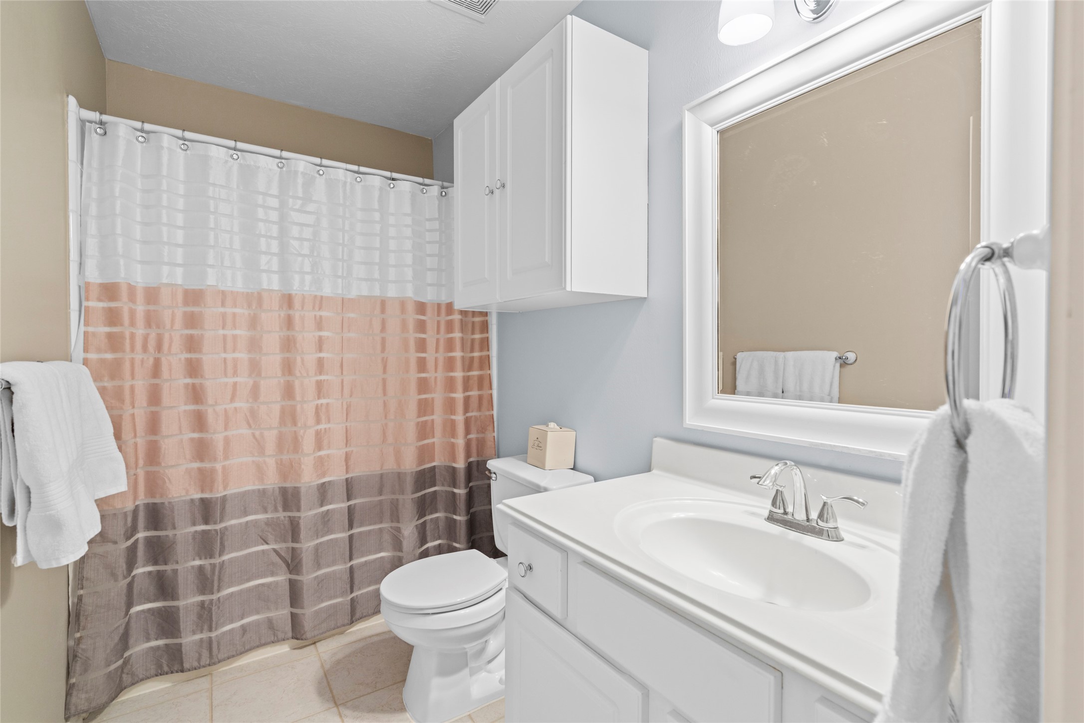 Bright secondary bathroom with generous vanity space, storage, and a clean, functional arrangement. The layout provides practical support for the home's additional bedrooms and family living spaces.