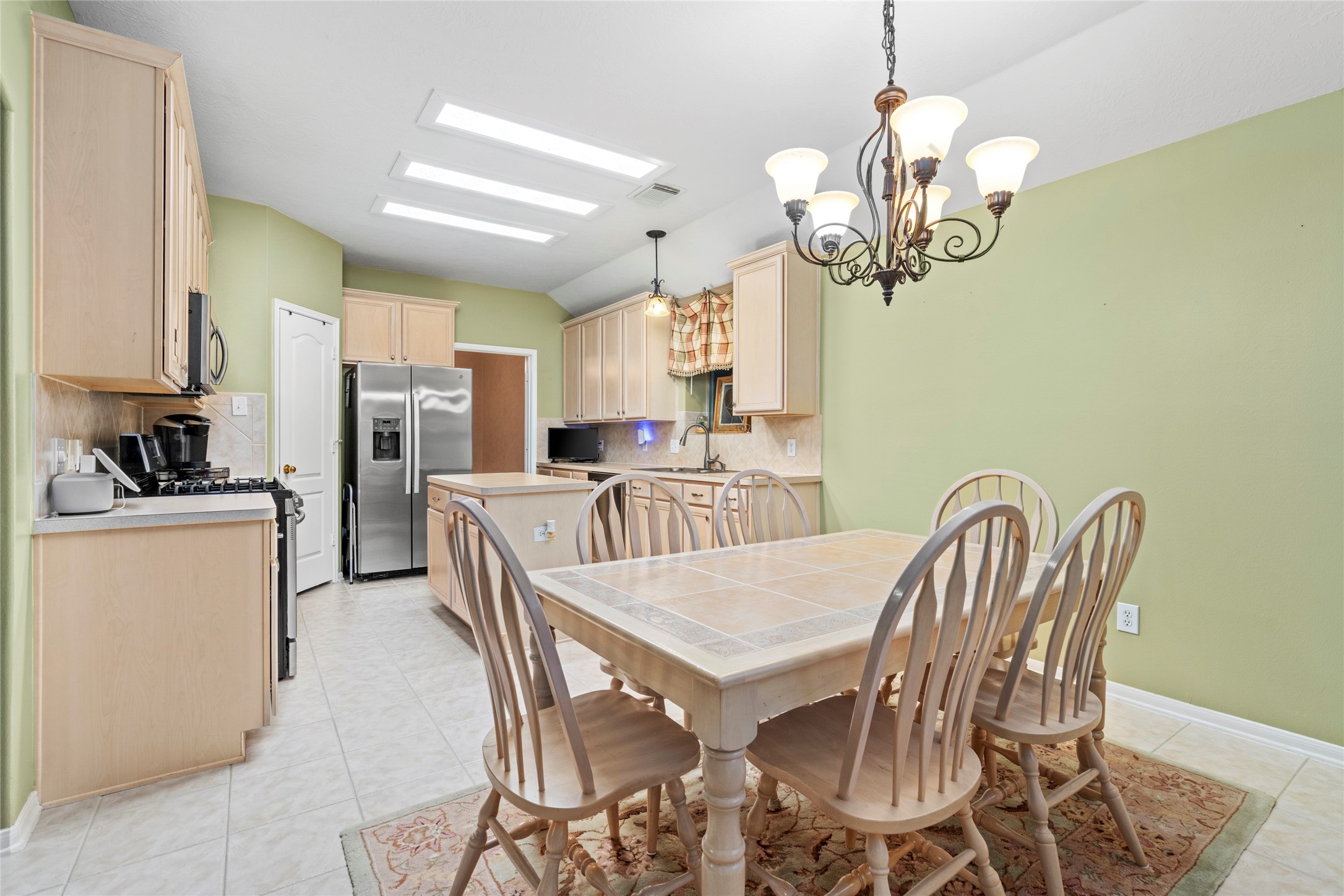 Spacious kitchen with abundant cabinetry and a dedicated dining area, offering the functionality buyers want for everyday cooking and gathering. The open arrangement allows the kitchen to remain connected to the home's living spaces rather than feeling isolated.