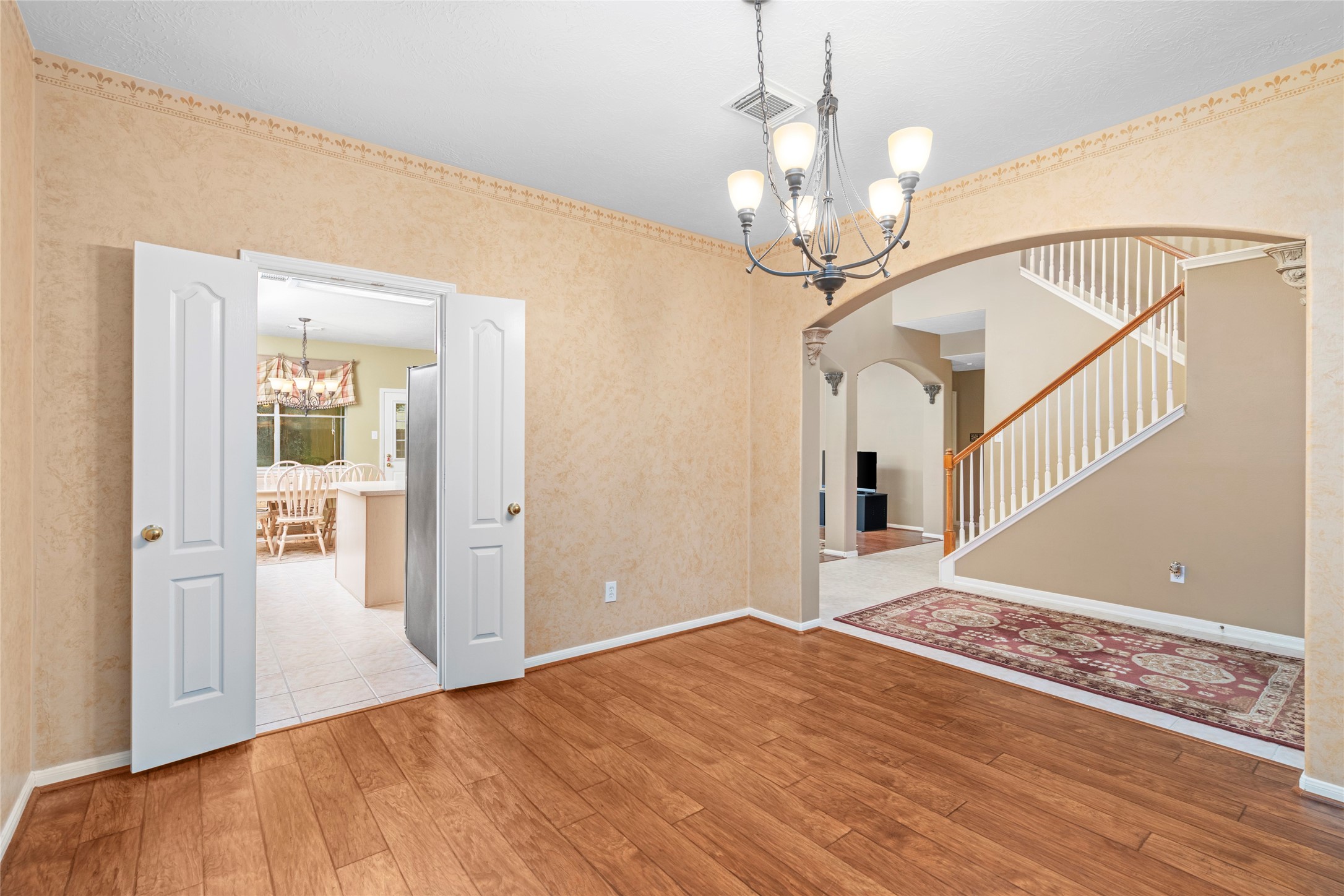 Another perspective of the formal dining area emphasizes the graceful archways and open connection to the staircase and adjoining living spaces. A flexible room like this gives buyers the option for memorable holiday dinners, everyday family meals, or a more elevated entertaining space.