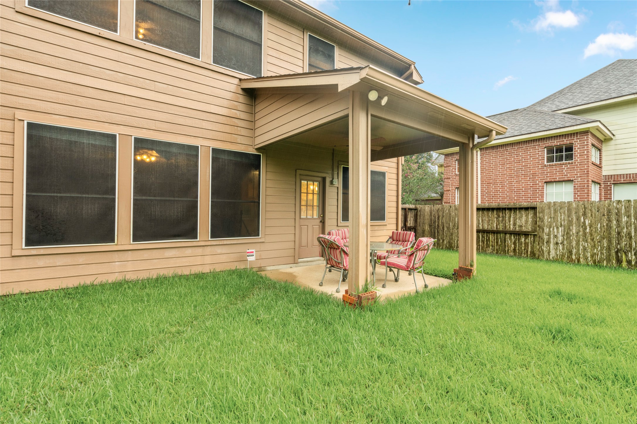 Covered patio overlooking the backyard provides a comfortable extension of the home's living space. It is easy to envision morning coffee, weekend gatherings, outdoor dining, or simply enjoying the backyard from a shaded setting.