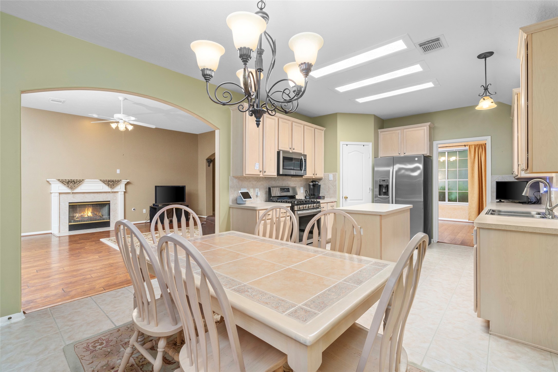 The kitchen opens toward the living area and fireplace, creating a practical layout for entertaining and keeping everyone connected. This is a strong feature for buyers who want a home where cooking, conversation, and everyday family life can happen in the same shared space.