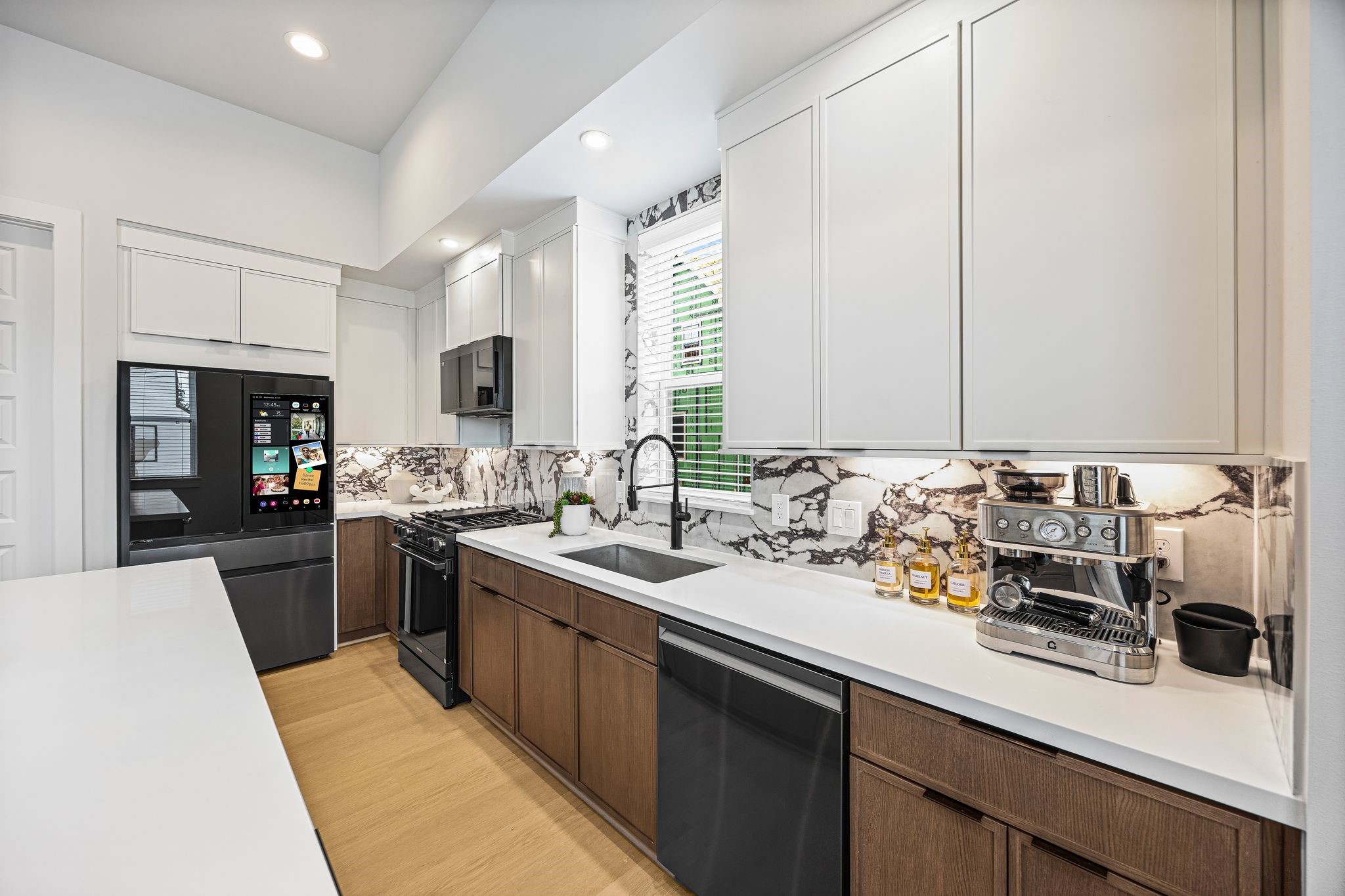 Sleek and modern kitchen featuring state-of-the-art appliances, elegant cabinetry, and a striking marble backsplash. **Model Home of similar layout & finishes.** Sleek and modern kitchen featuring state-of-the-art appliances, elegant cabinetry, and a striking marble backsplash. **Model Home of similar layout & finishes.**