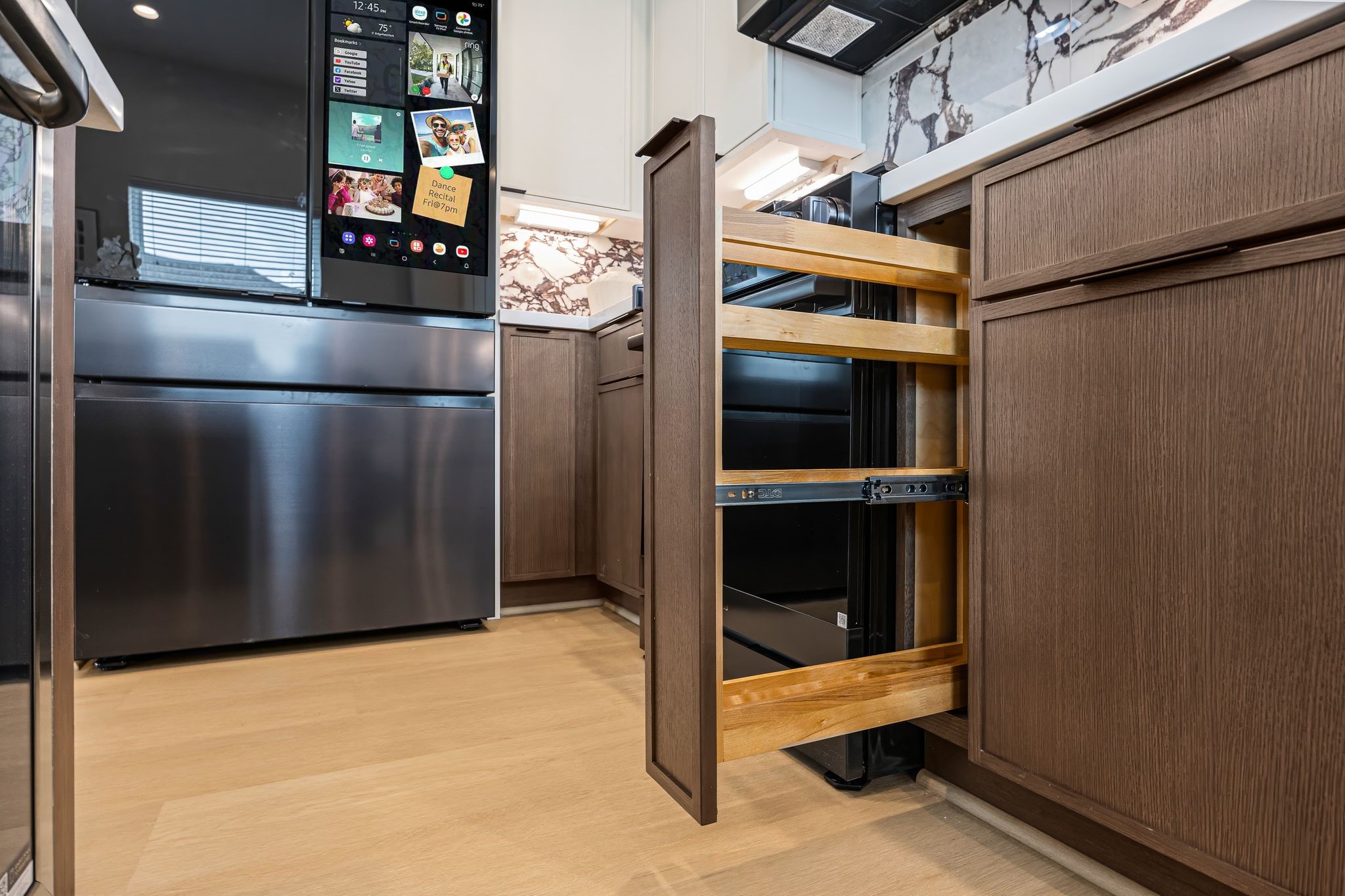Modern kitchen with sleek stainless steel appliances, elegant wood cabinetry, and innovative storage solutions, ideal for culinary enthusiasts. **Model Home of similar layout & finishes.**