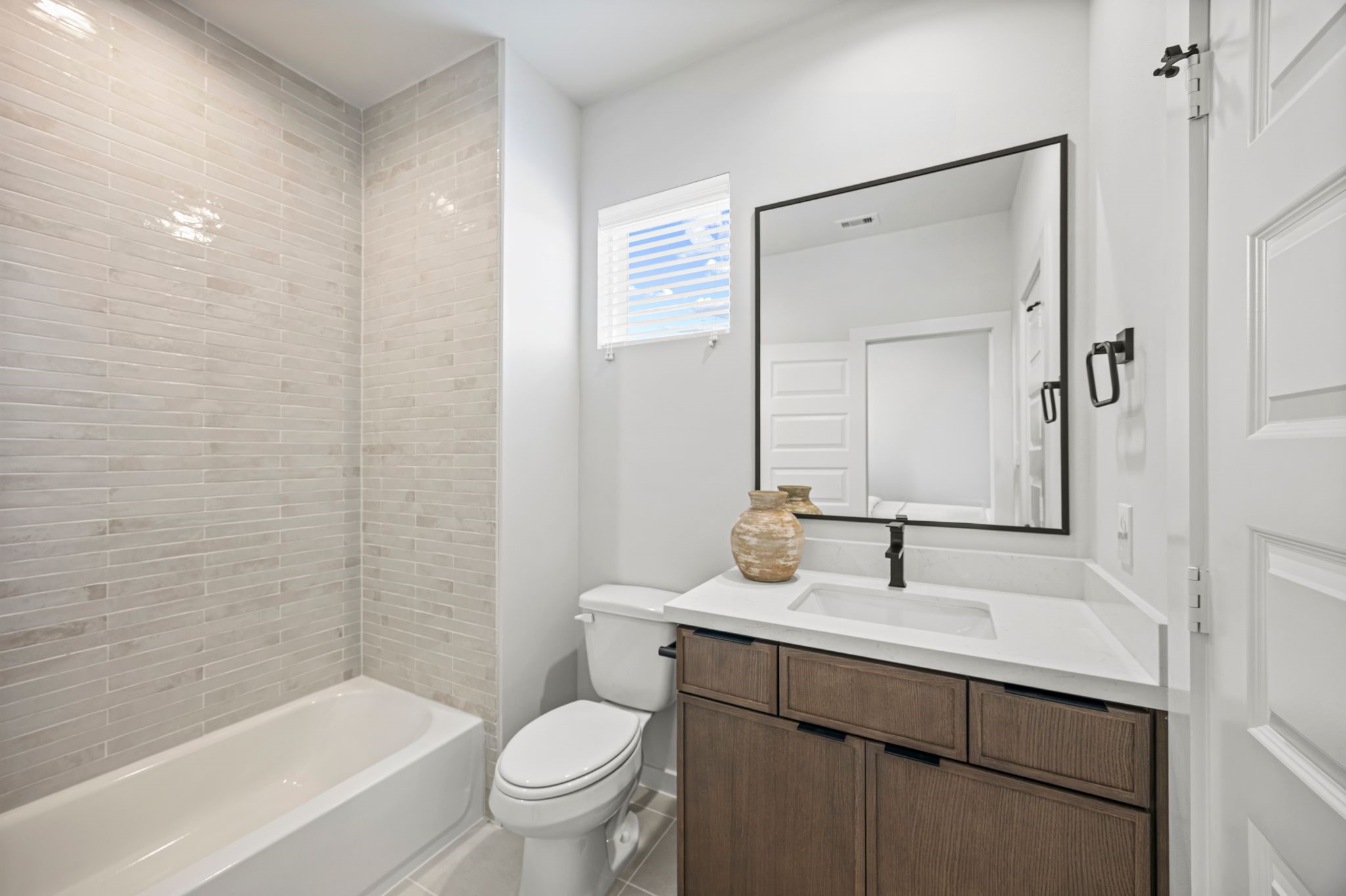 Bright and inviting, the third-floor bathroom offers a modern retreat with sleek tile work, elegant fixtures, and ample natural light. **Model Home of similar layout & finishes.**