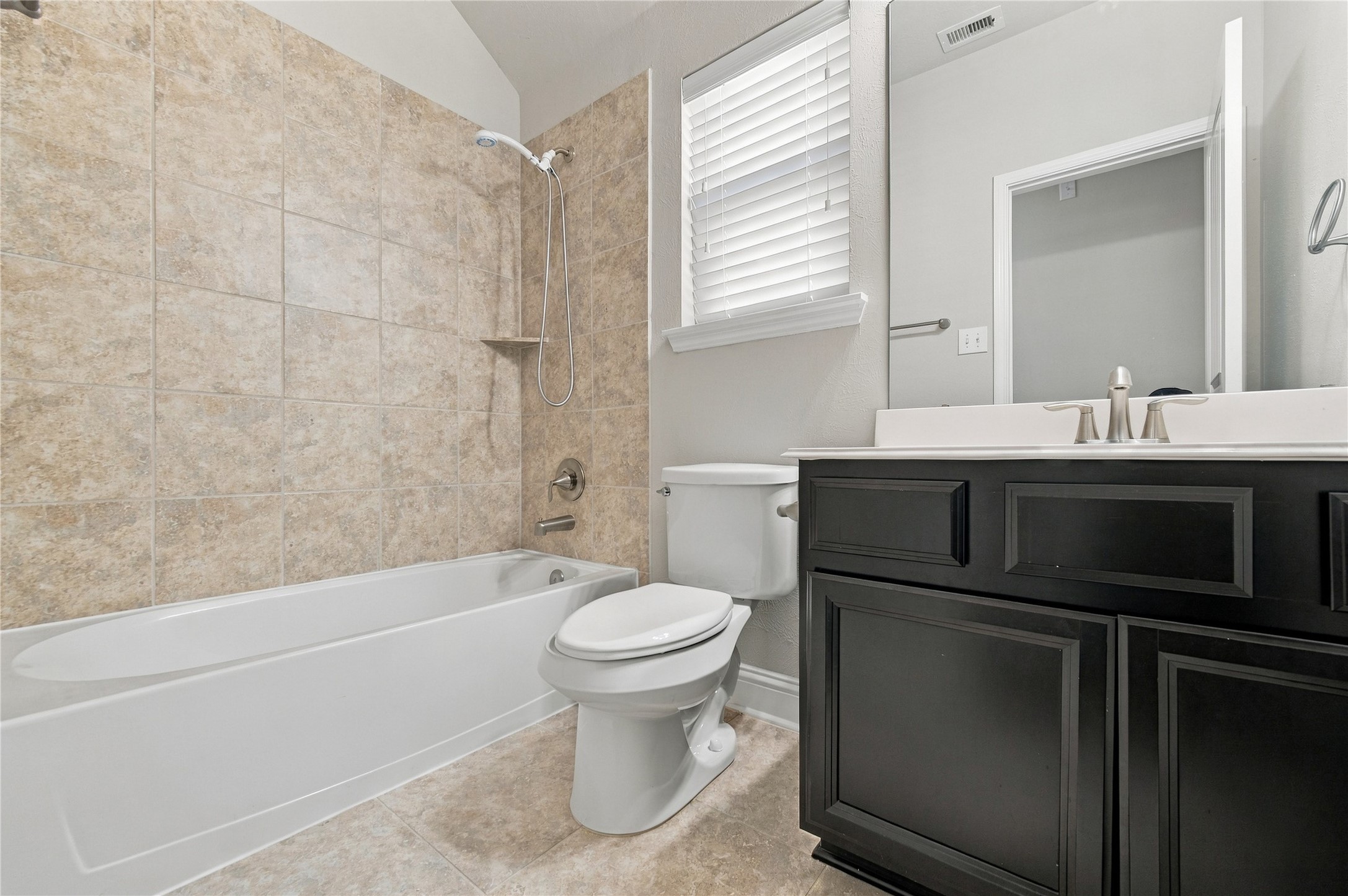 The secondary bathroom offers a sink with cabinet for storage, and combo tub and show.