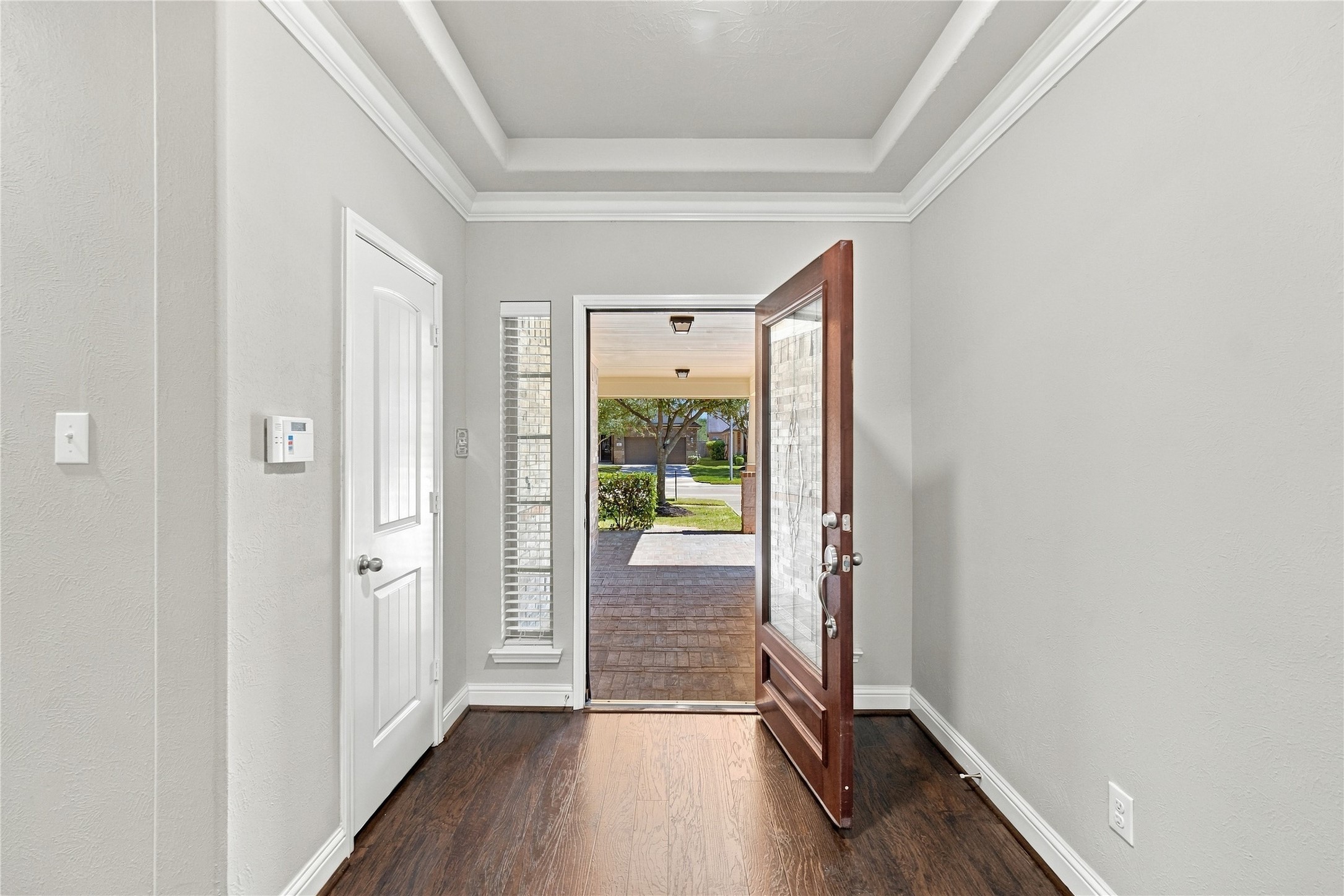 A beautiful wood front door with elegant glass detailing creates a warm and inviting welcome as you enter the home.