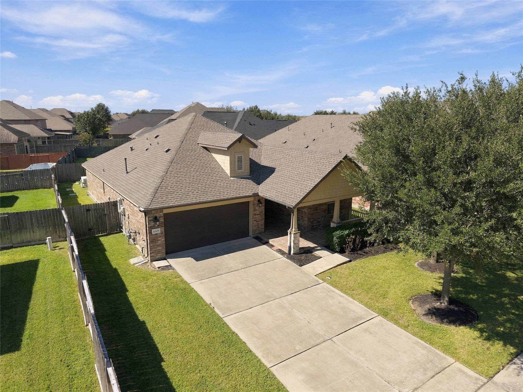 The aerial birds-eye view offers a unique perspective of the home, showcasing its roofline, and landscaping, driveway.