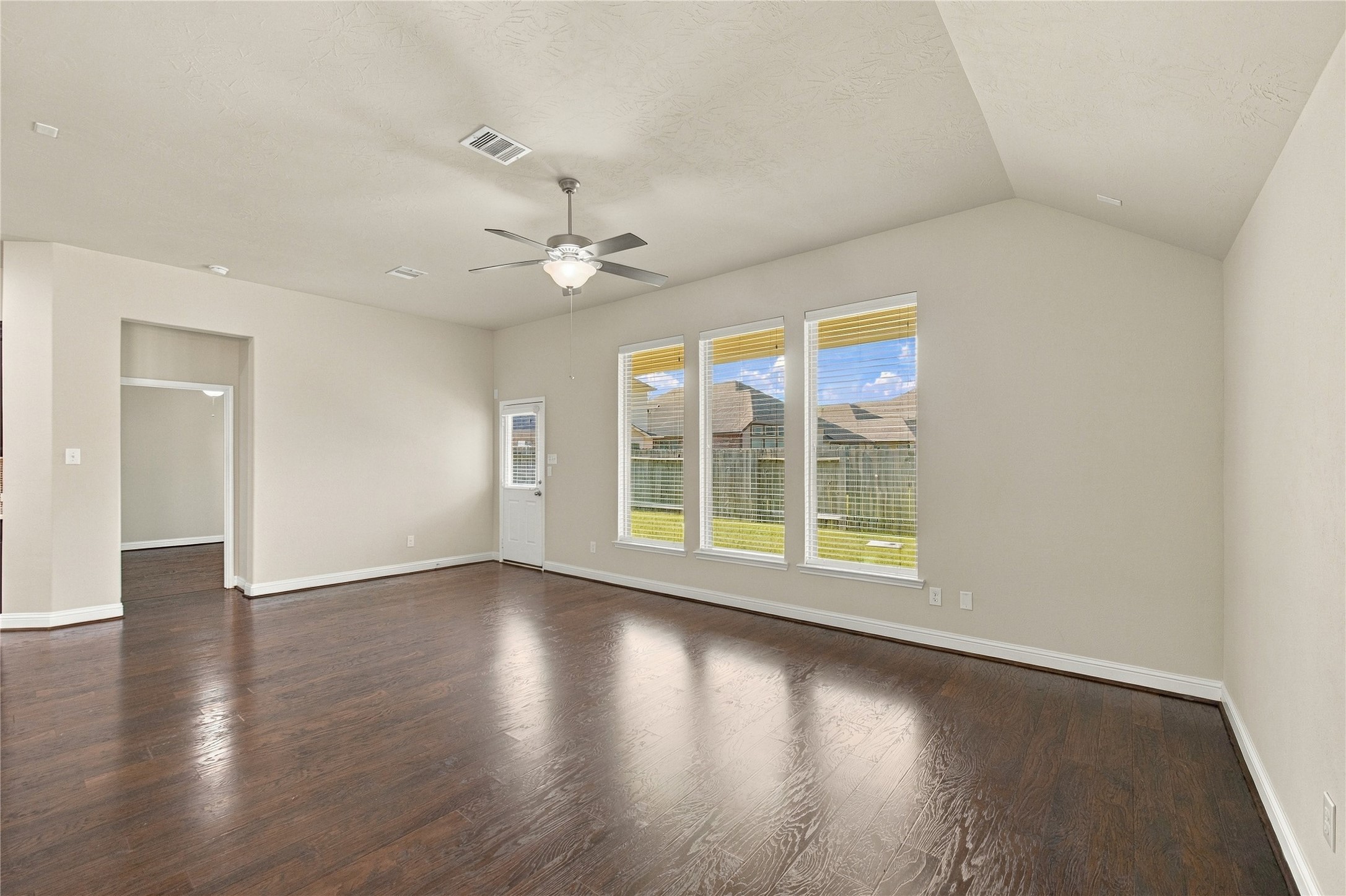 The open layout of the family room creates a seamless flow into the kitchen, while natural light streams through the windows.