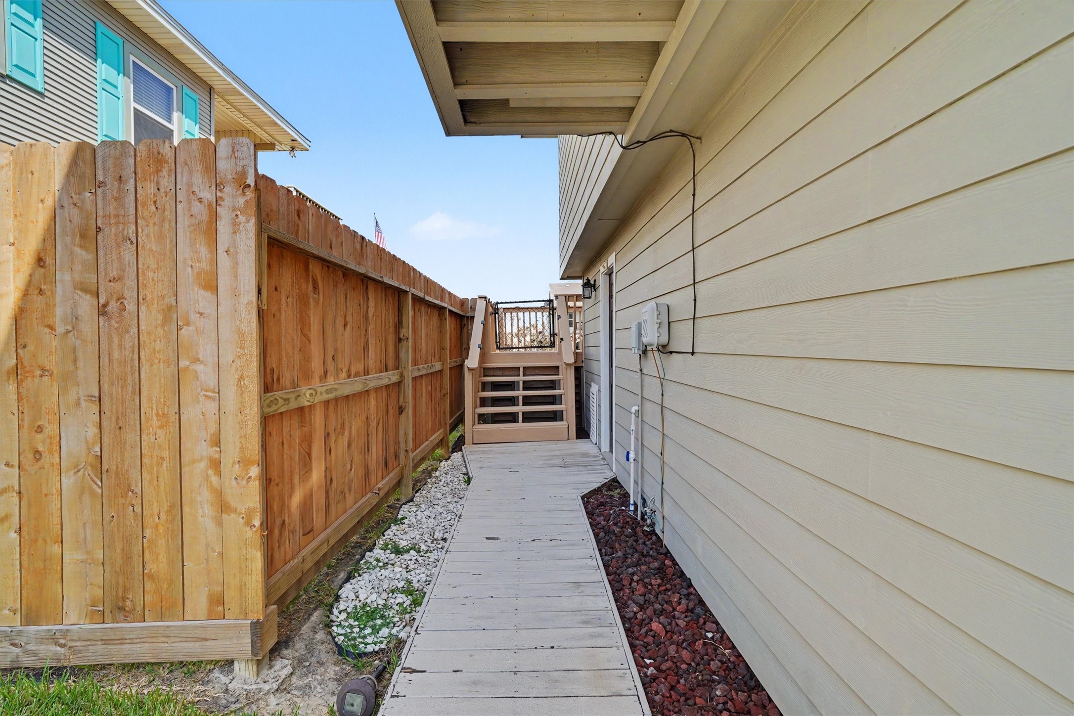 Side walk way to the stairs and side door into the garage. One of the updates is the Hardi siding on the home