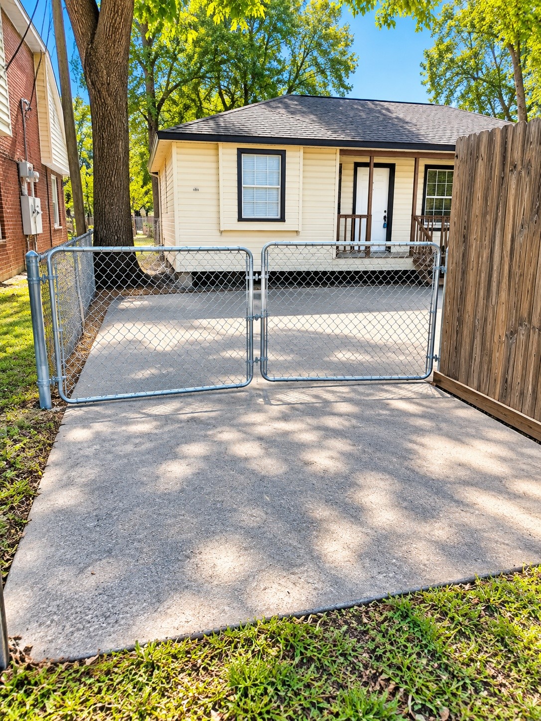 gated driveway - concrete starts closer to the fence--AI used to brighten and clean up look gated driveway - concrete starts closer to the fence--AI used to brighten and clean up look