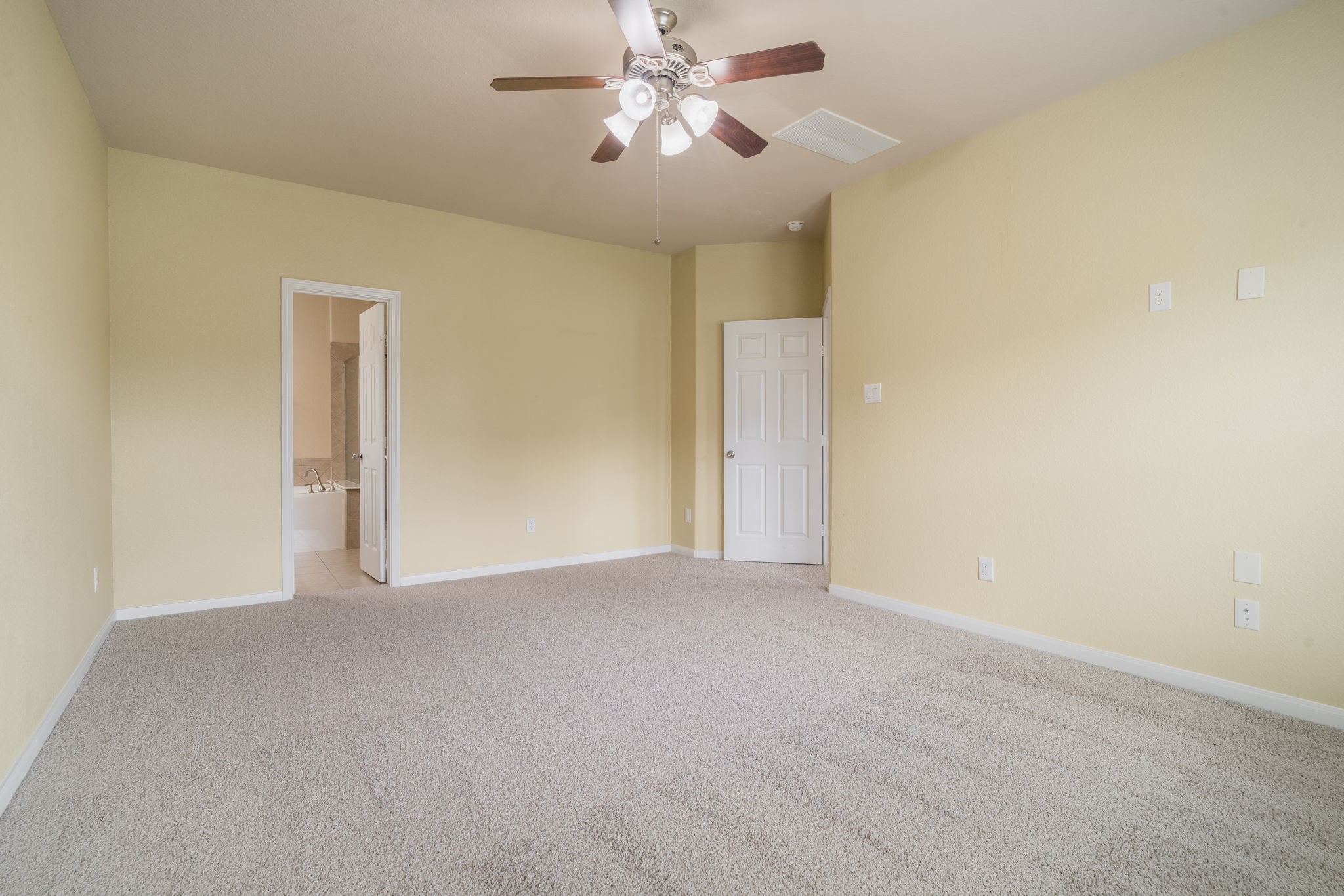 Spacious primary suite offering generous room for a sitting area, soft neutral finishes & direct access to the private en-suite bath.