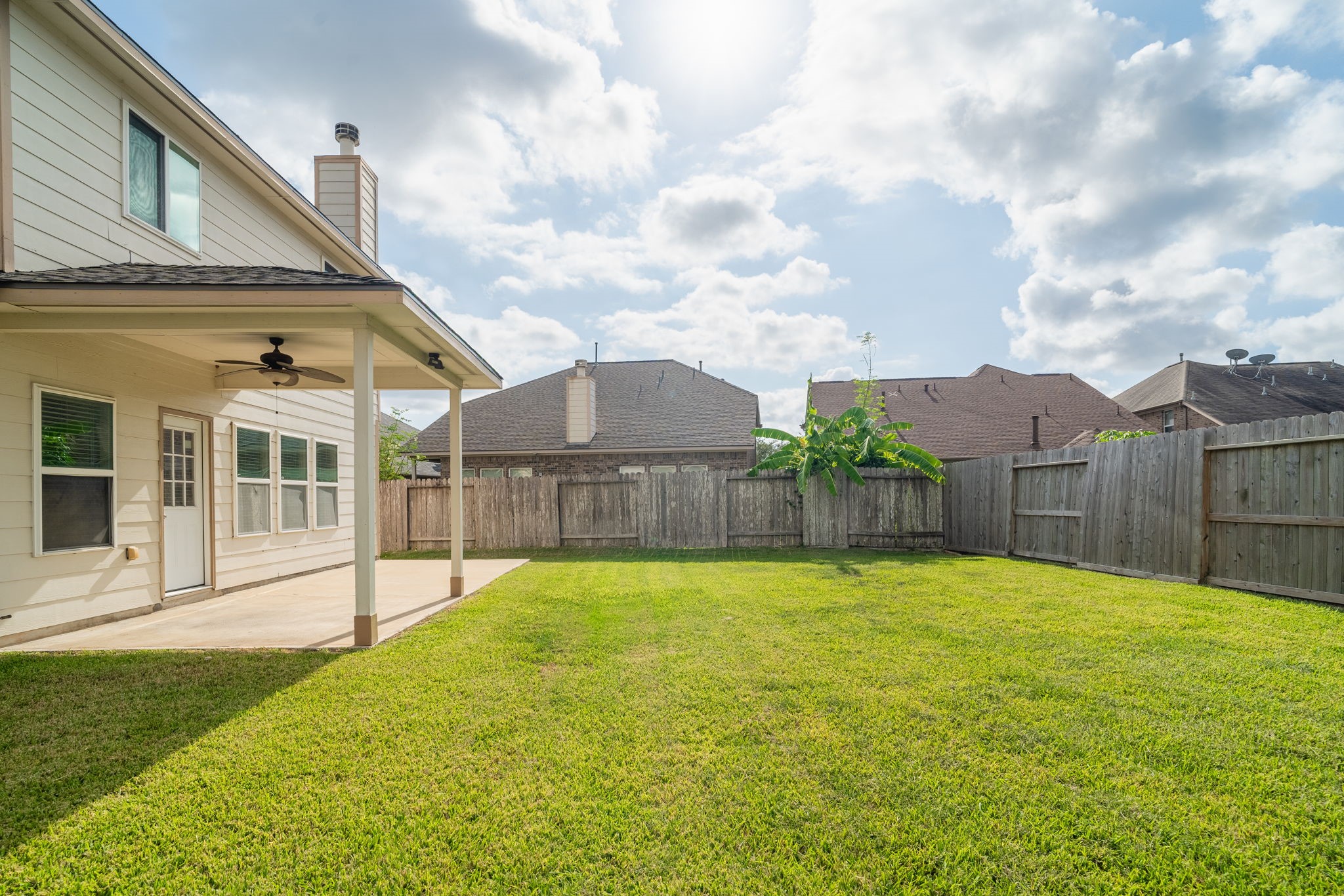 Extended concrete patio offers both covered & open-air spaces for outdoor dining, lounging & entertaining, with easy access to the spacious backyard.